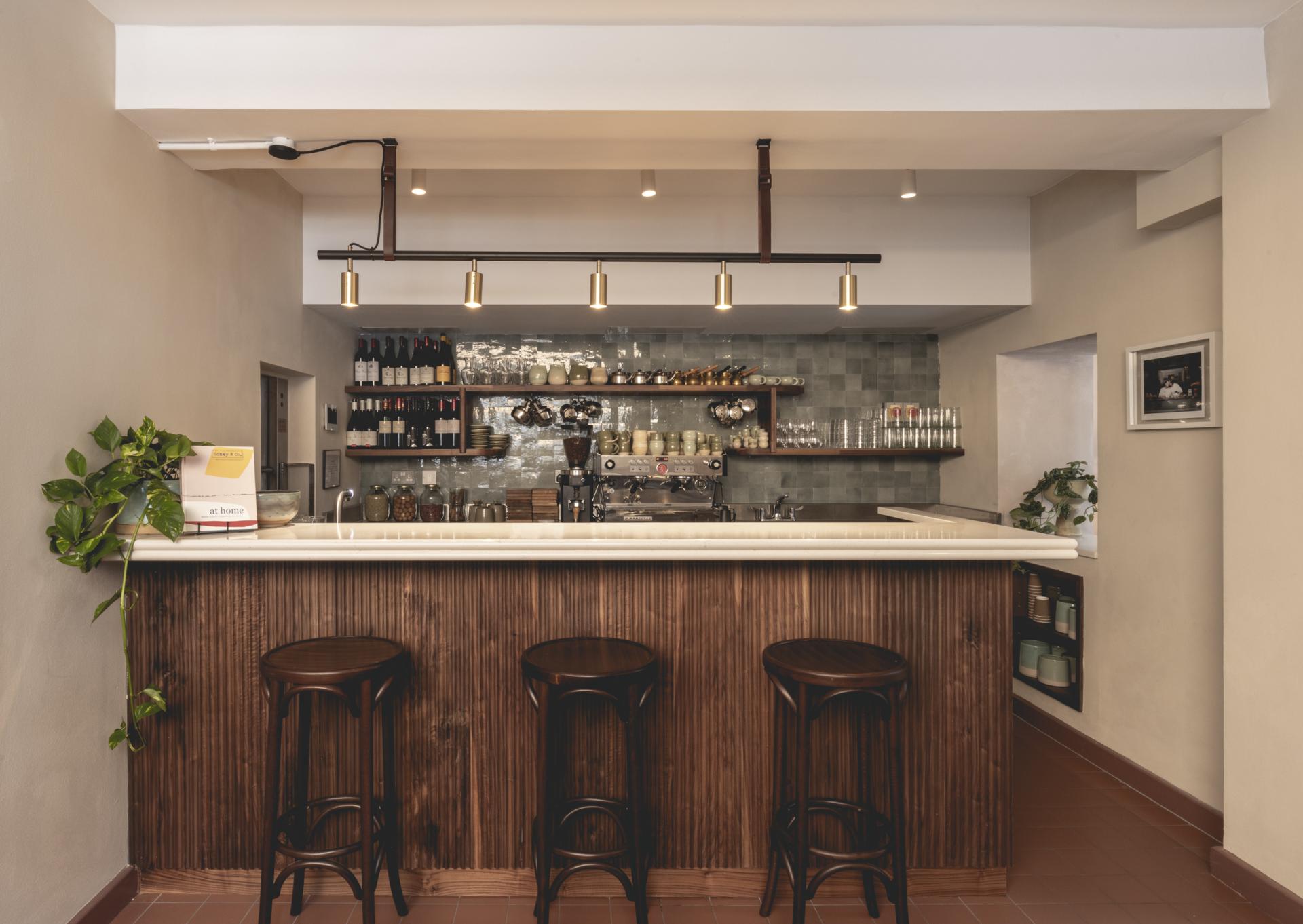 Stylish café bar at Honey & Co Bloomsbury featuring sleek design, wooden accents, and a variety of beverages.