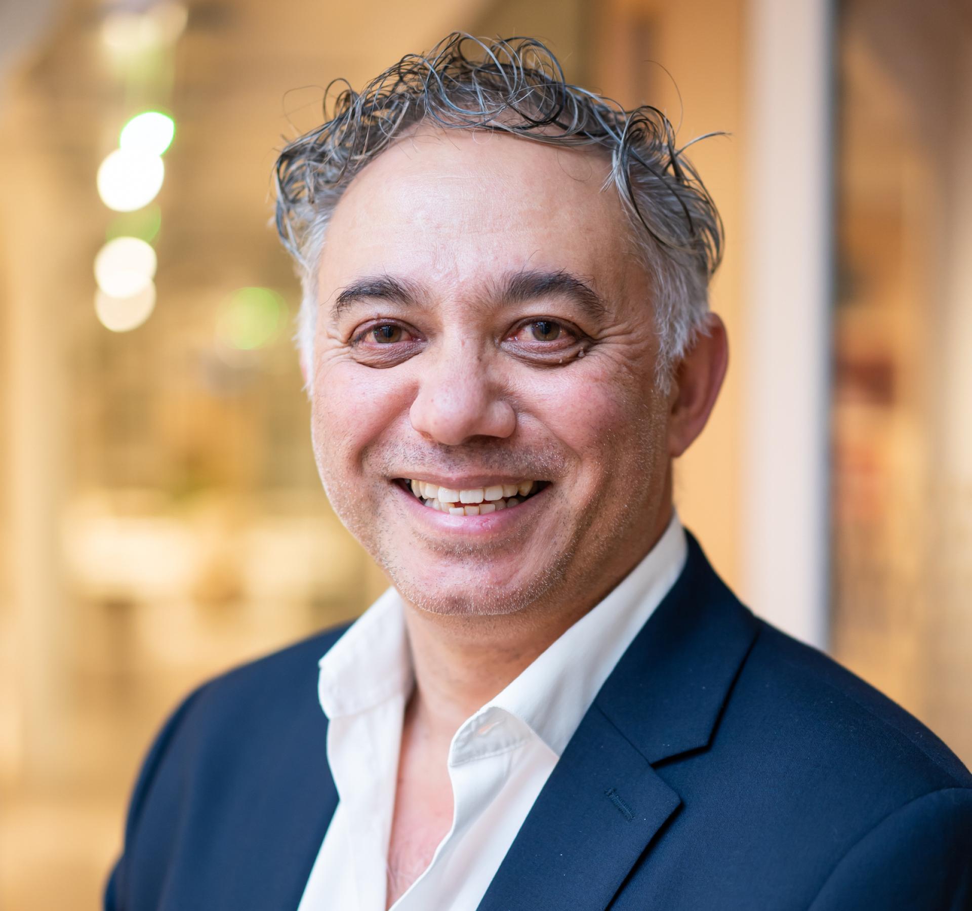 Smiling professional in a suit, symbolizing innovation and leadership in the future of education.