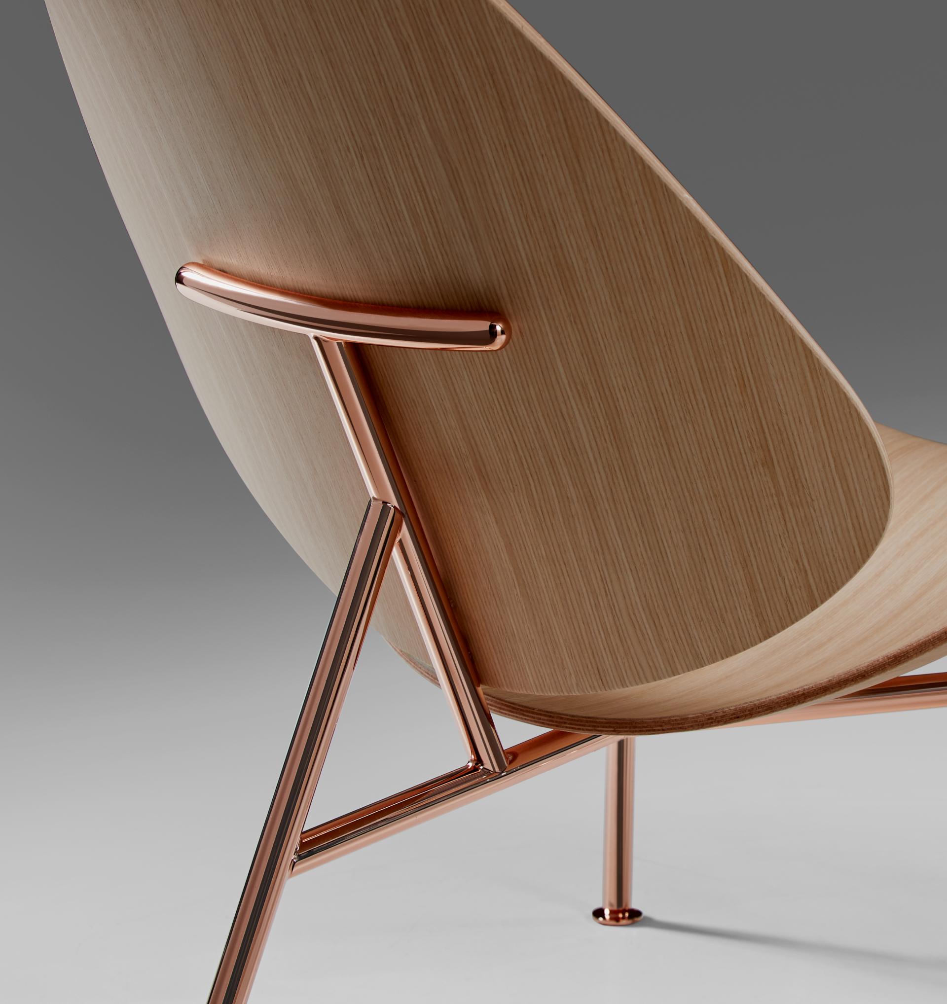Elegant Pedersen lounge chair designed by Thomas Pedersen, featuring a wooden backrest and sleek copper metal frame.