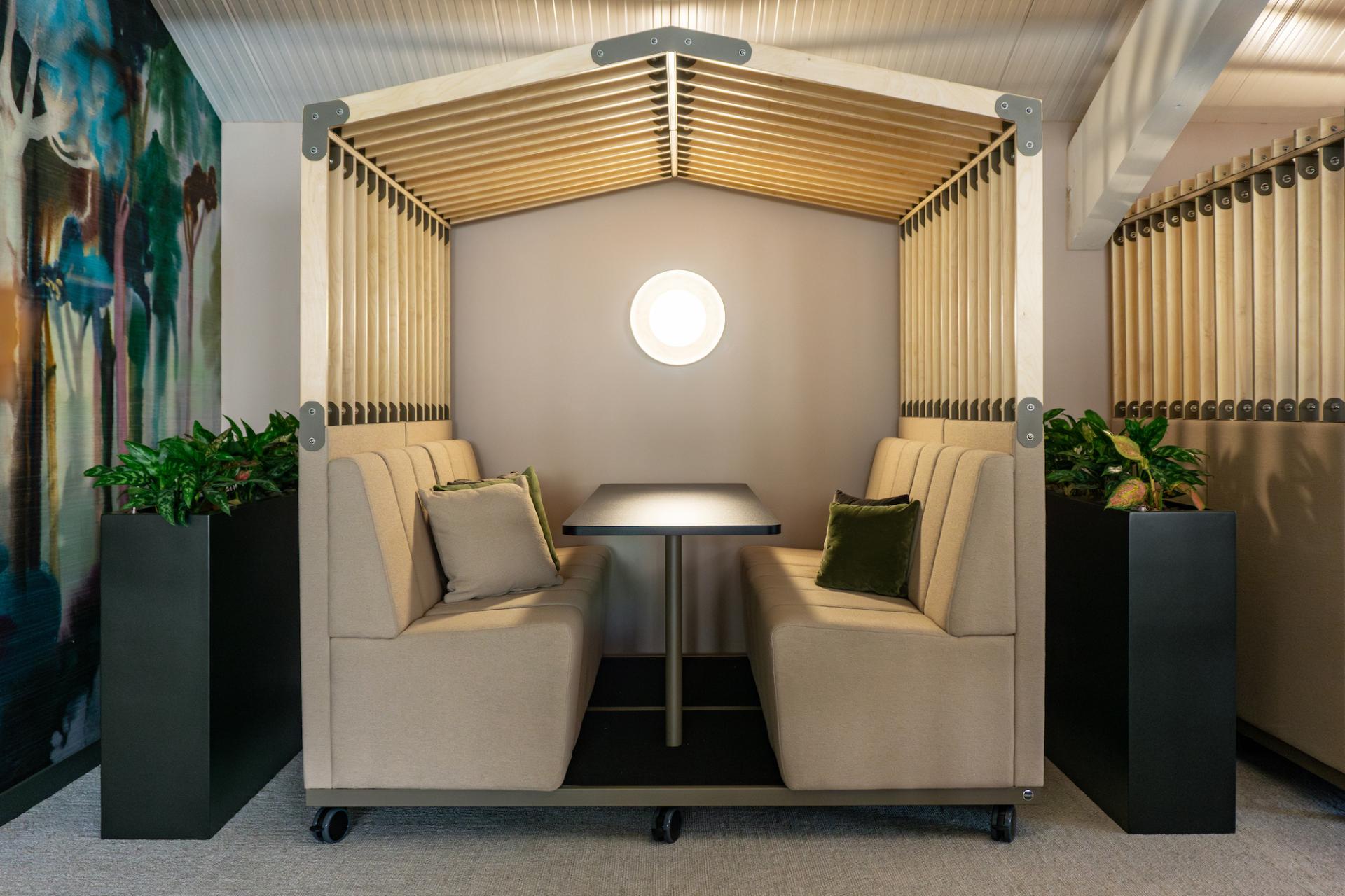 Vibrant meeting space at the Liz Hickson Academy featuring cozy seating, natural light, and greenery for enhanced collaboration.