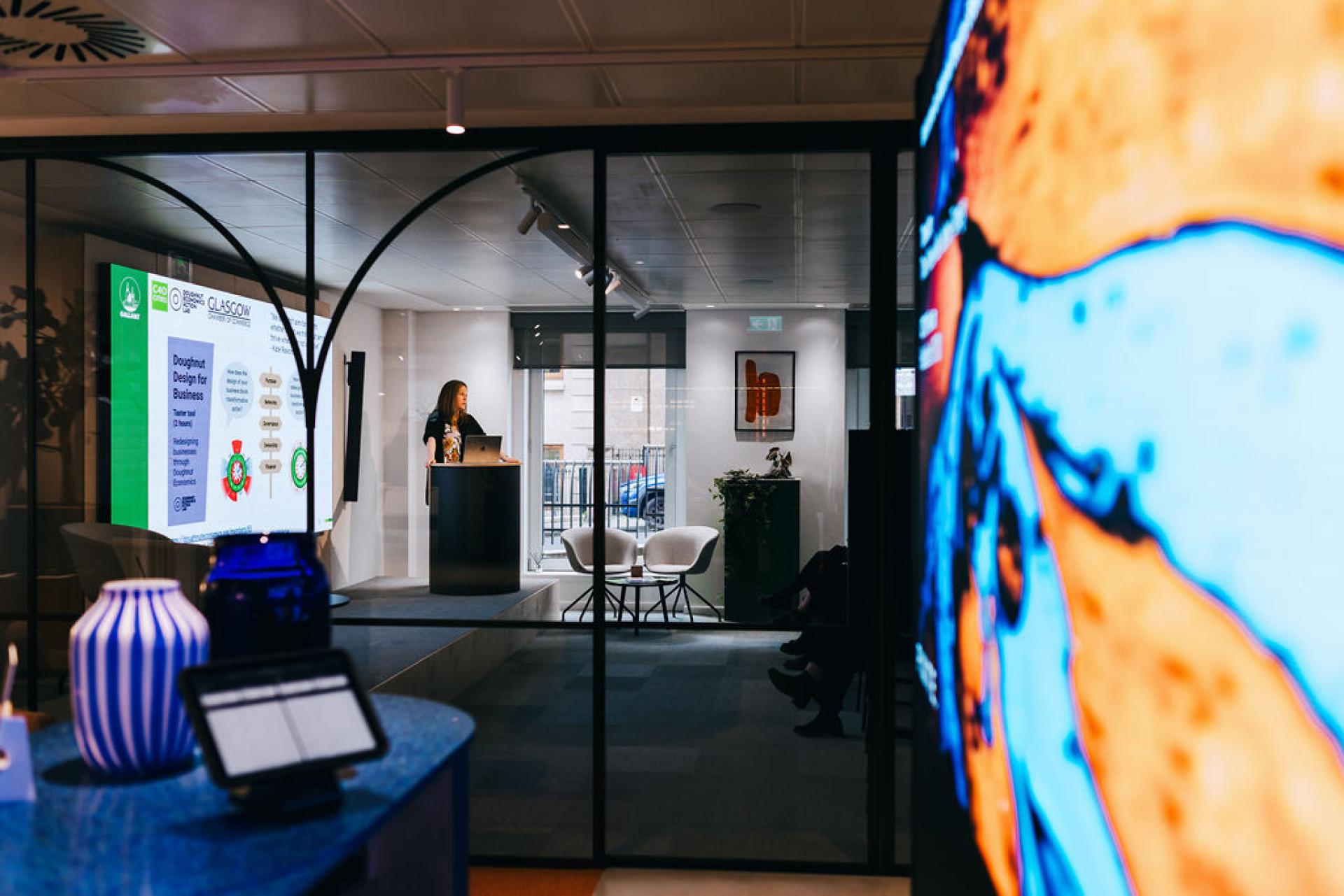 Professor Jaime Toney discusses sustainable solutions, with a presentation highlighting doughnut design principles for business.