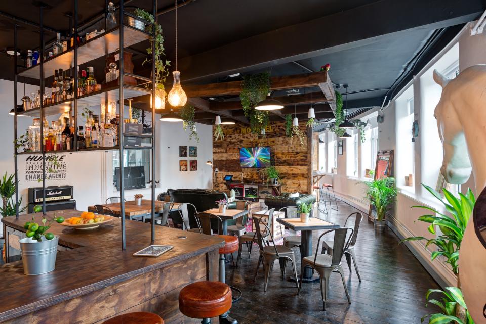 Modern office space with industrial design elements, vibrant decor, and a cozy seating area in Movember's London headquarters.