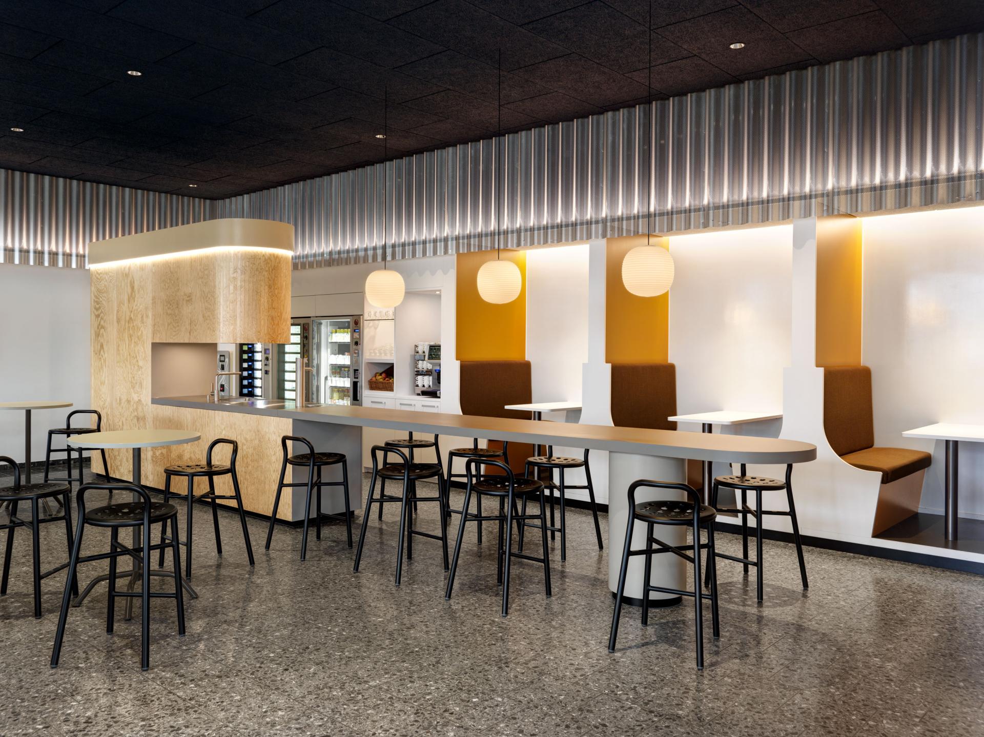Modern interior design of a café space by Studio Gessaga, featuring sleek seating and stylish lighting for Ferrum AG.
