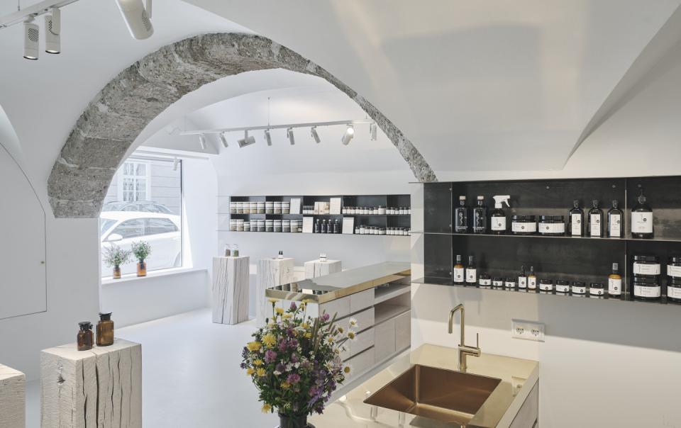 Bright, minimalist interior of Saint Charles store showcasing natural cosmetics, adorned with elegant wood and stone elements.