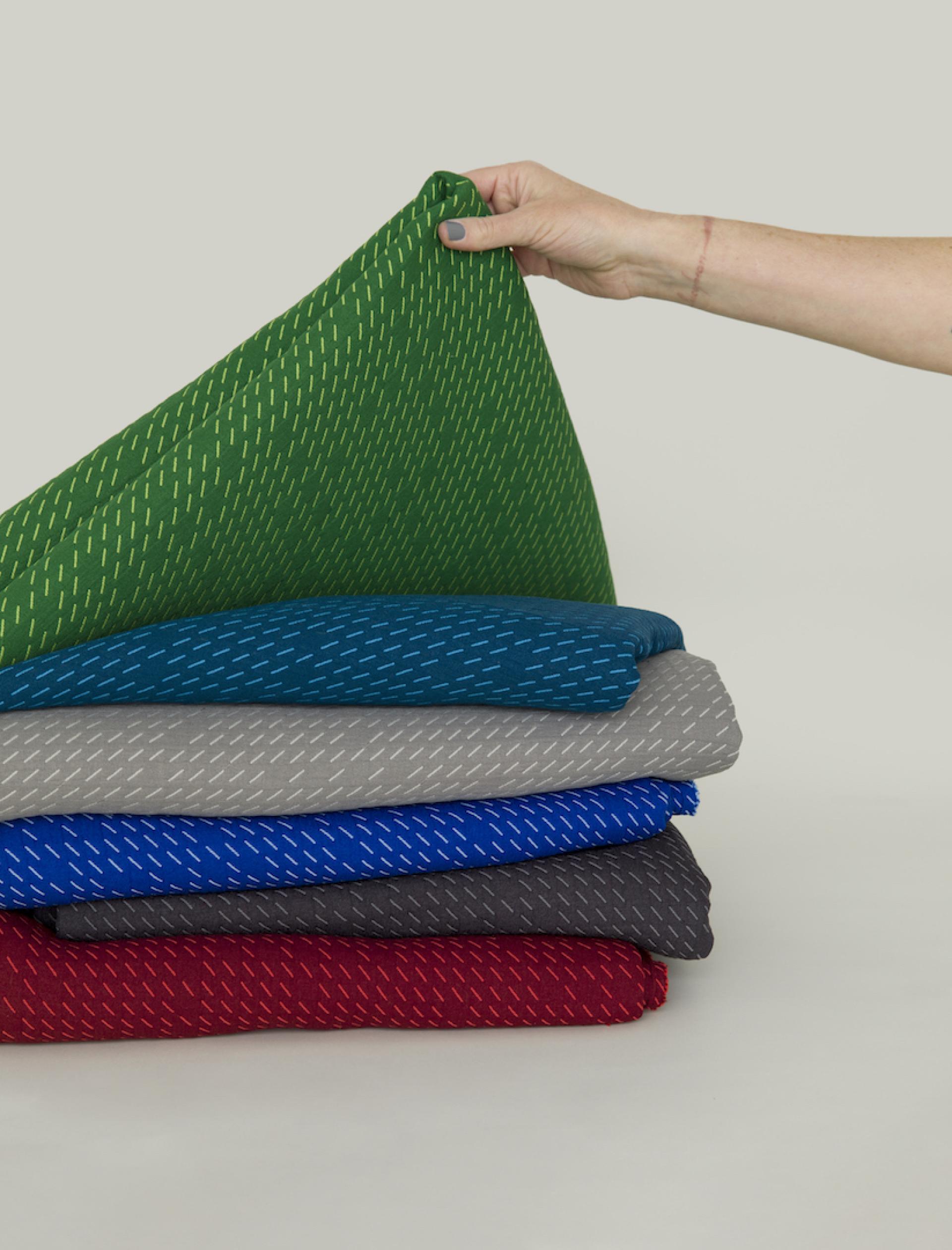 Vibrant textiles from the UP Collection by Kelly Harris Smith, showcasing sustainable fabric designs in various colors.