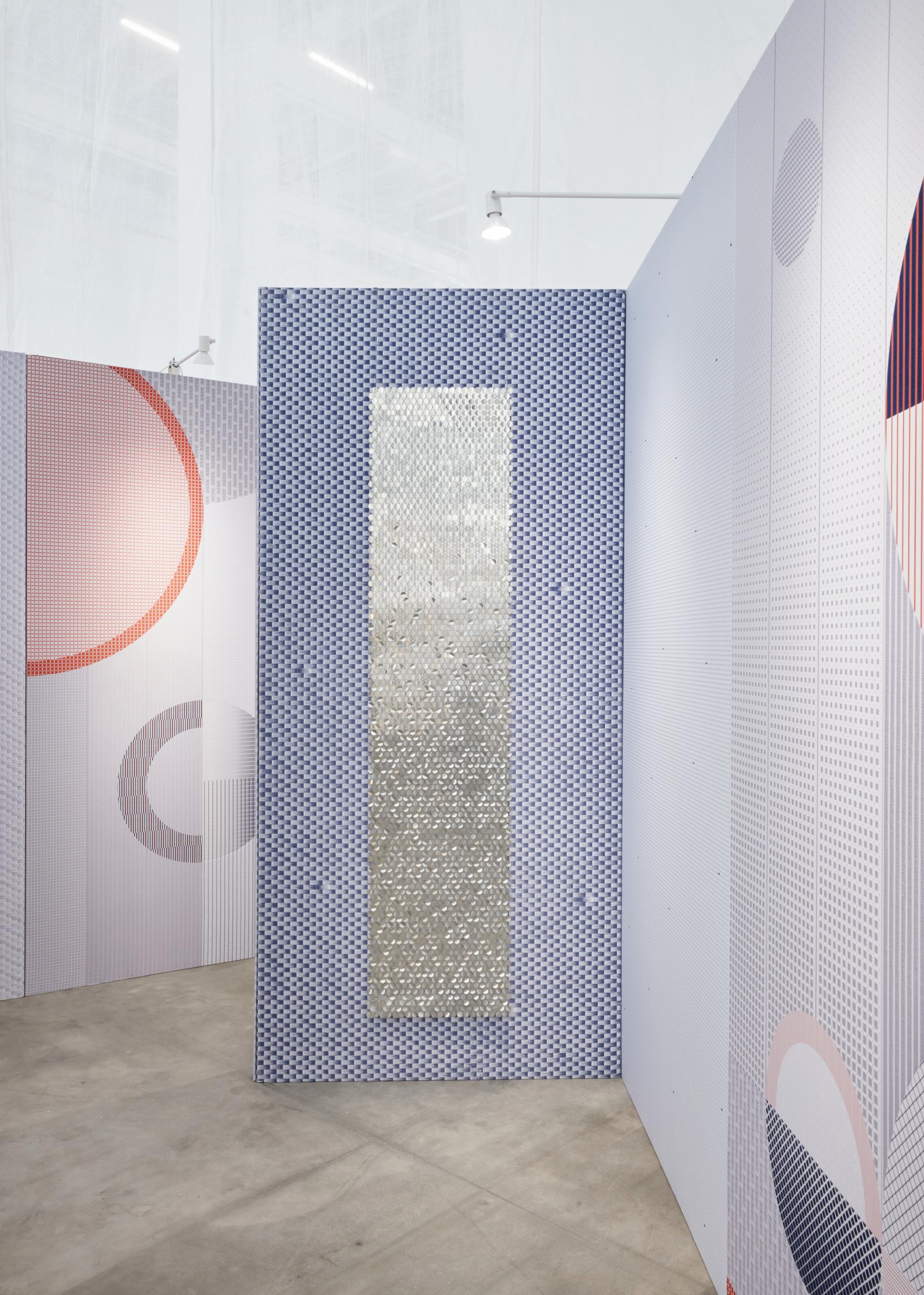 Interior design featuring sensory elements, including patterned walls and a reflective surface, promoting wellbeing in biotechnological spaces.