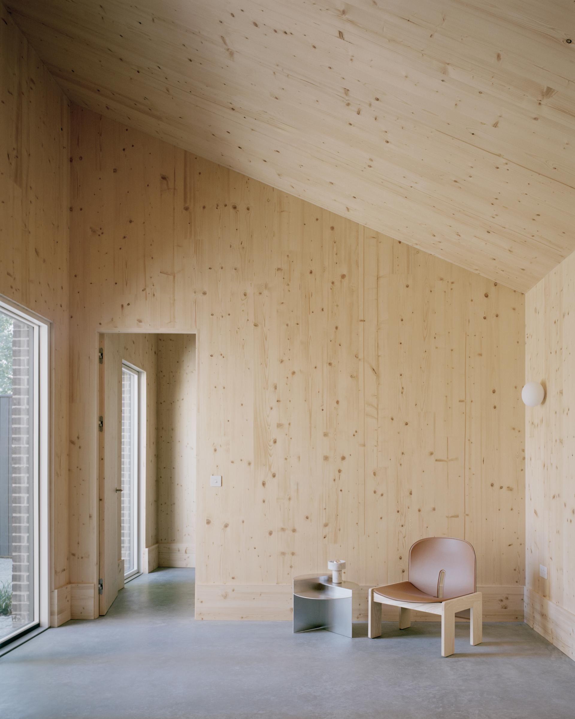 Modern interior of Tree Courtyard House showcasing sustainable cross-laminated timber walls and minimalist design elements.