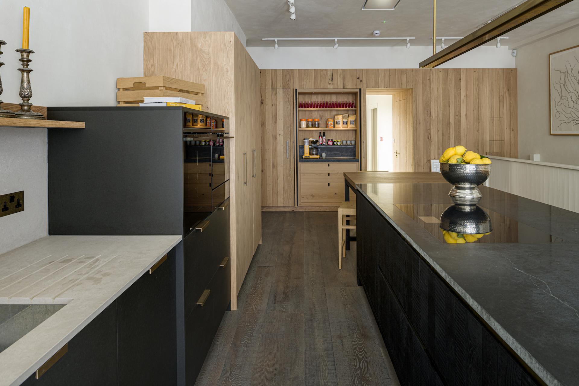 Modern kitchen design featuring Caesarstone surfaces, wooden cabinetry, and a countertop display of fresh lemons.