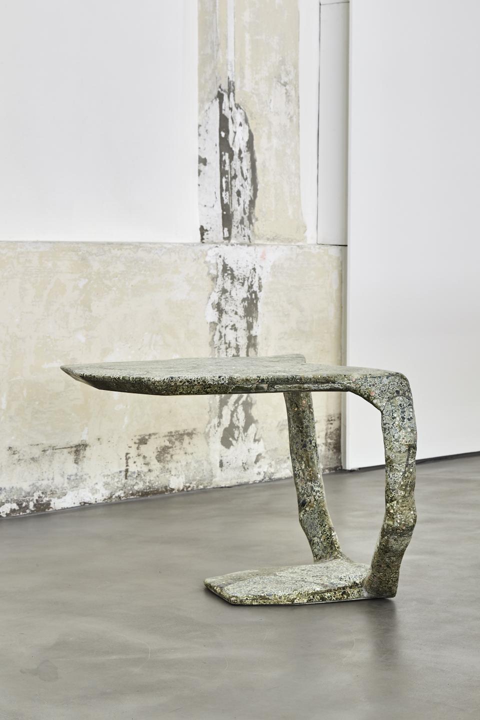 Sculptural furniture piece designed by Vincenzo de Cotiis, showcasing unique materials and organic forms in a minimalist setting.