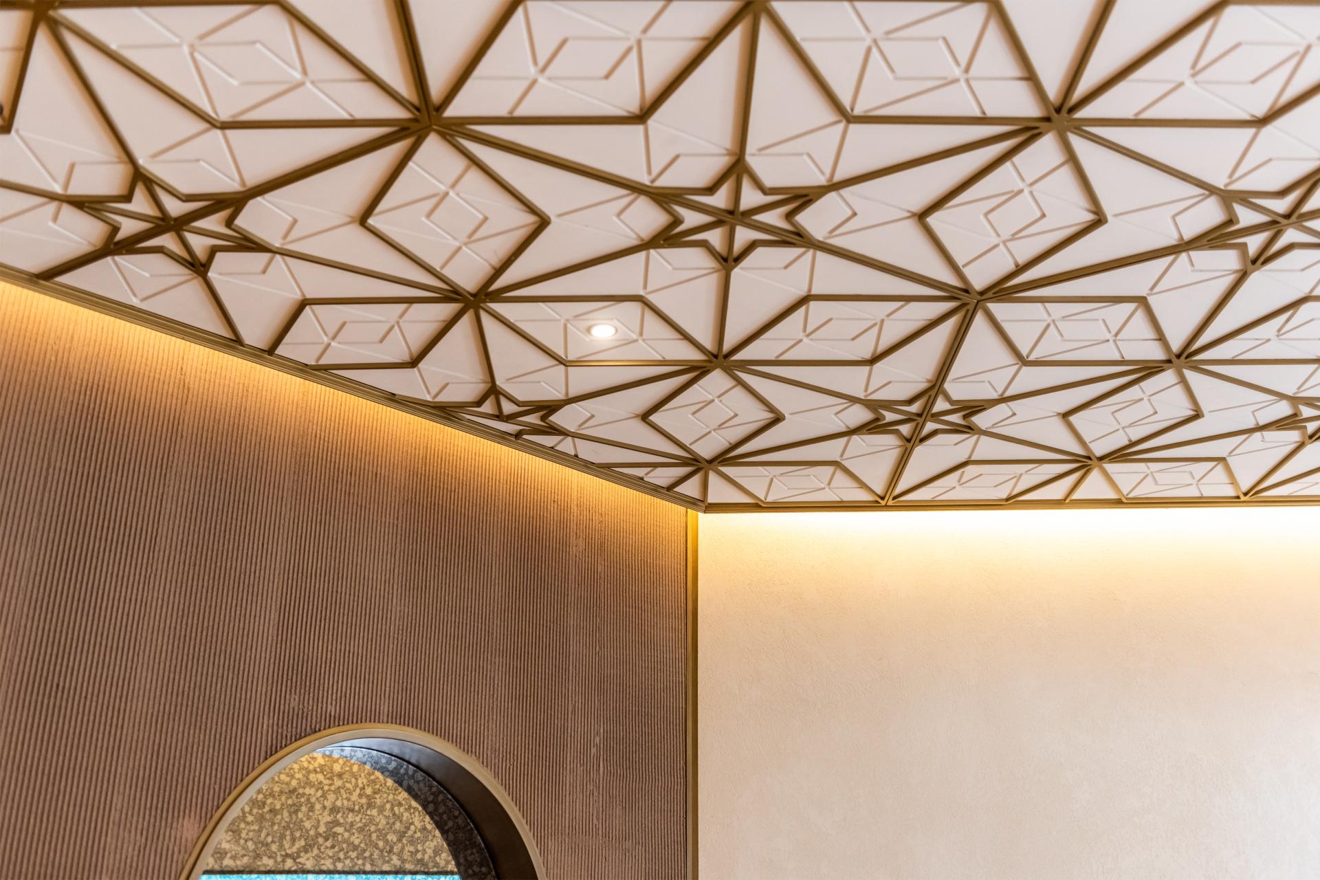 Elegant geometric ceiling design with warm ambient lighting in renovated Persian restaurant Anar, Souk Madinat Jumeirah, Dubai.