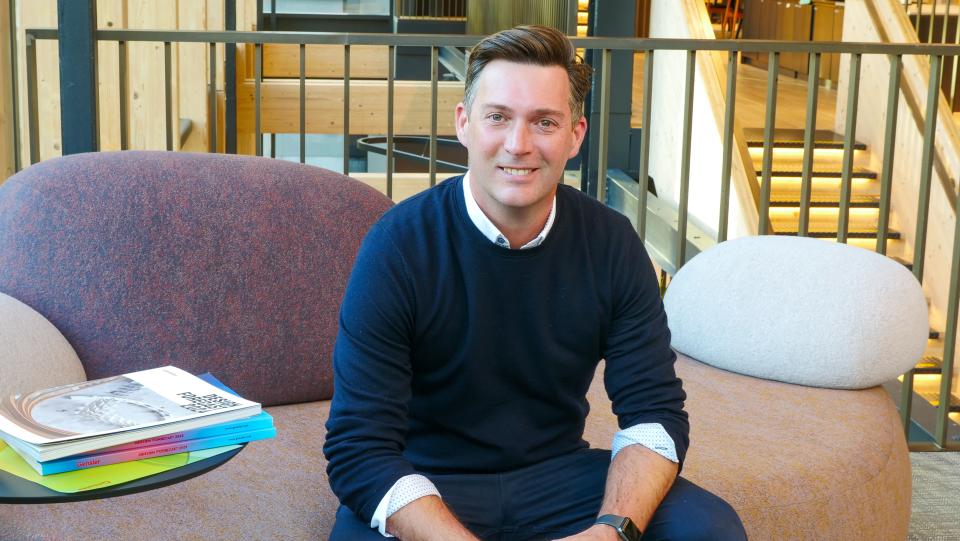 John Badman, Gensler's residential leader, seated in a contemporary office space, promoting innovative design for multi-purpose living.