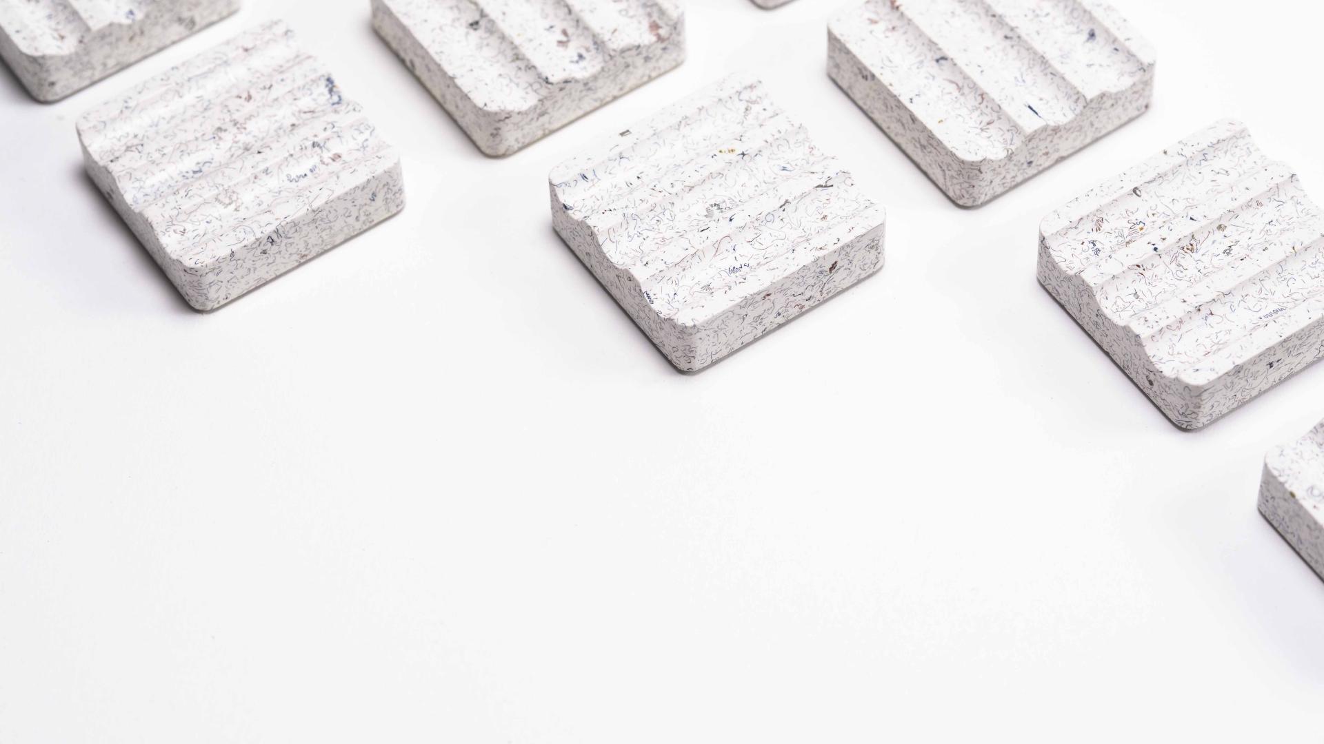 Ebonite terrazzo desk rests by AJOTO showcase a modern, textured design, enhancing workspace aesthetics and functionality.