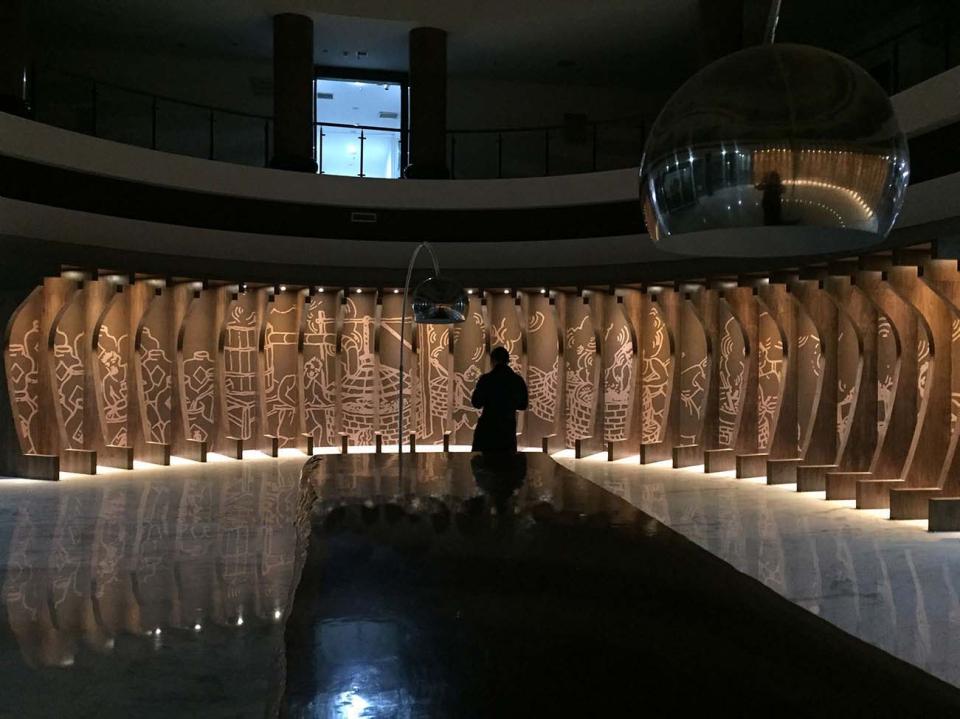 Interactive sensory installation at a Chinese liquor factory, featuring illuminated wood panels with artistic engravings, creating a unique experience.
