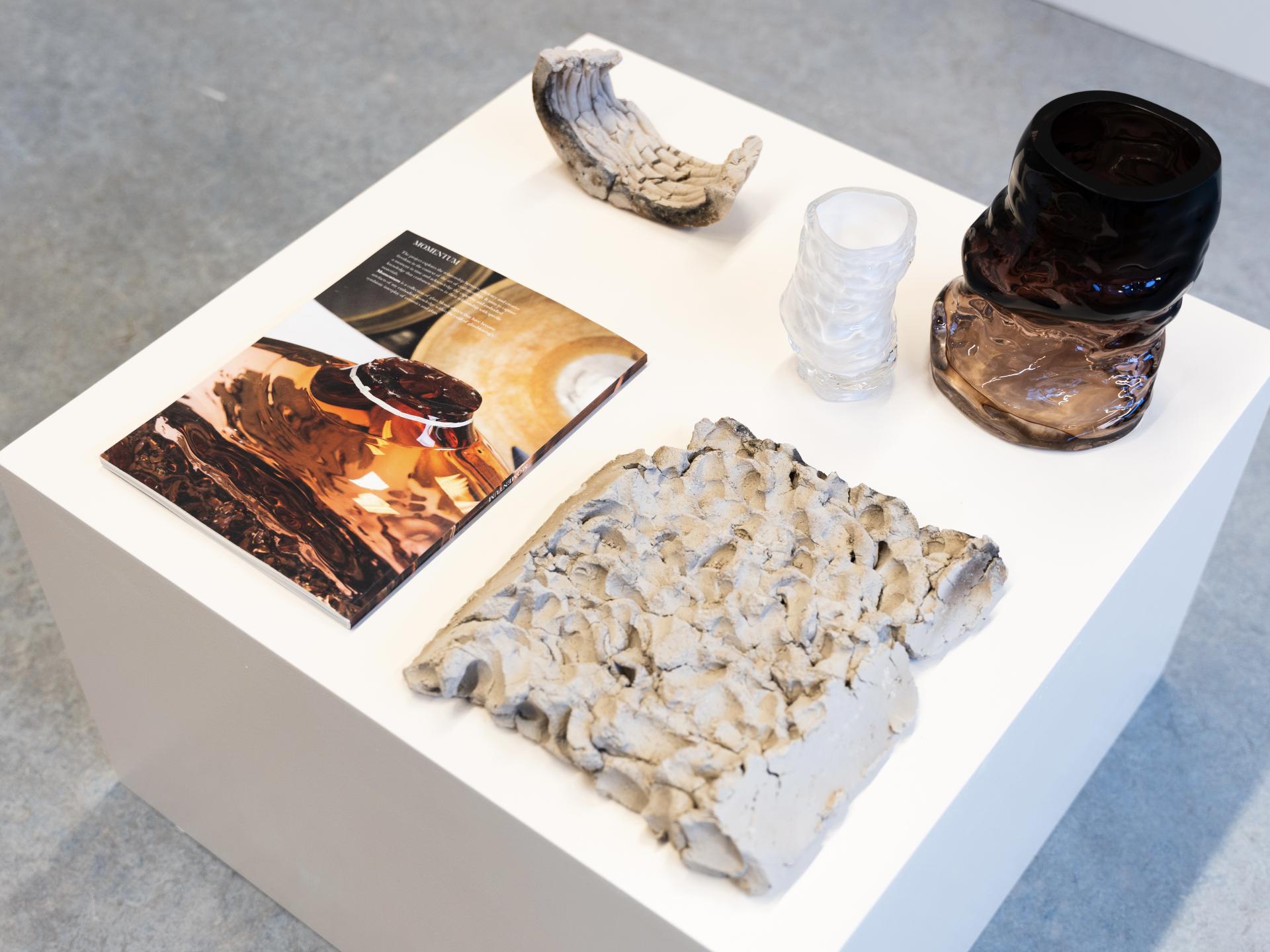 Ceramics and a design magazine displayed on a white table, showcasing modern craftsmanship and vibrant colors from Dutch Design Week 2023.