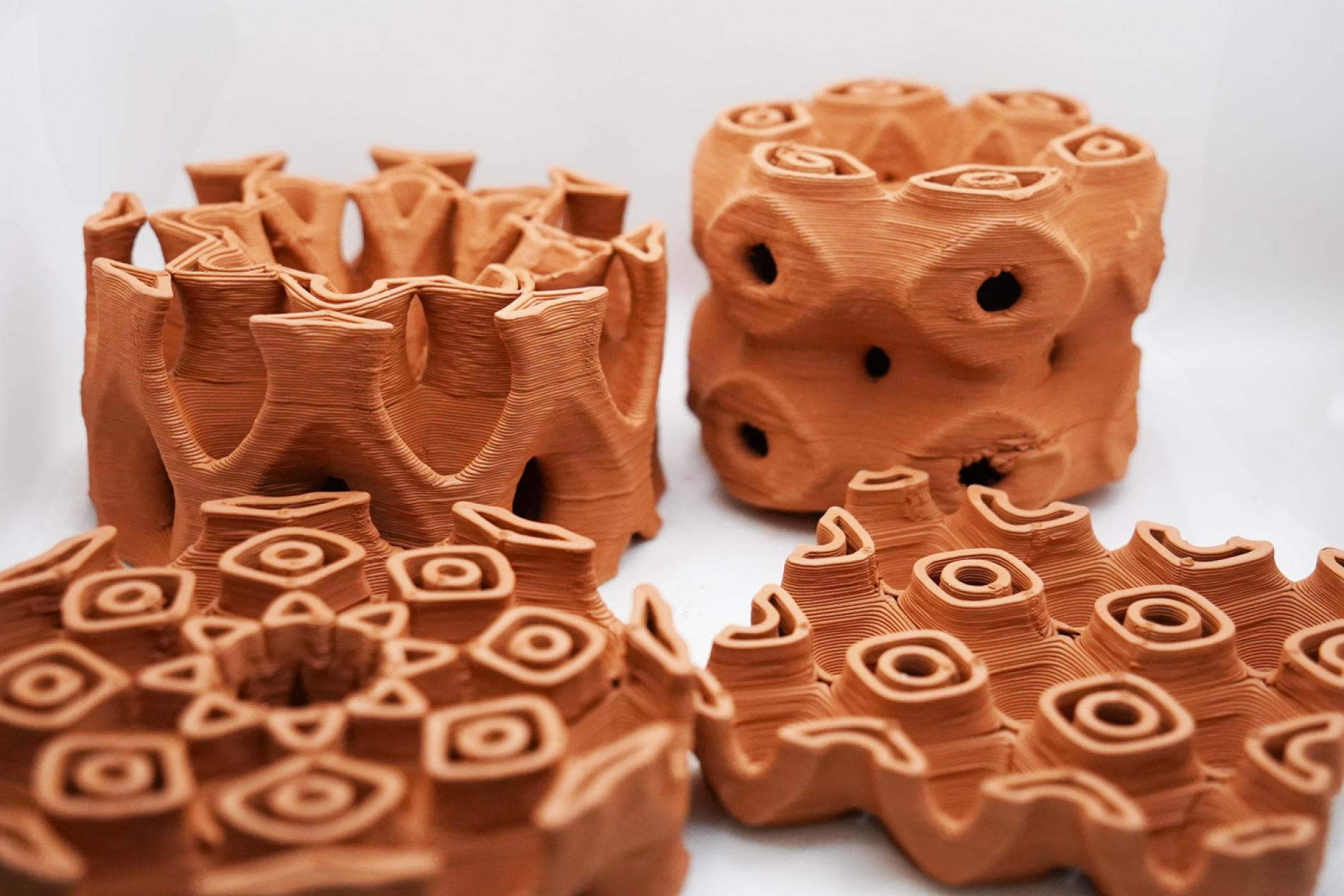 Innovative clay structures showcasing 3D-printed designs for environmentally friendly building cooling solutions.