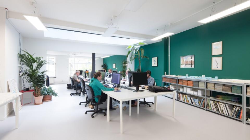 Modern architect studio featuring collaborative workspace, greenery, and creative design materials, highlighting Dutch architecture culture.