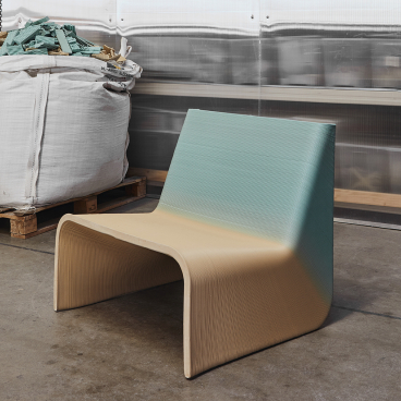 Ermis chair by The New Raw, showcasing a unique zero-waste design with layered pastel tones in an industrial setting.
