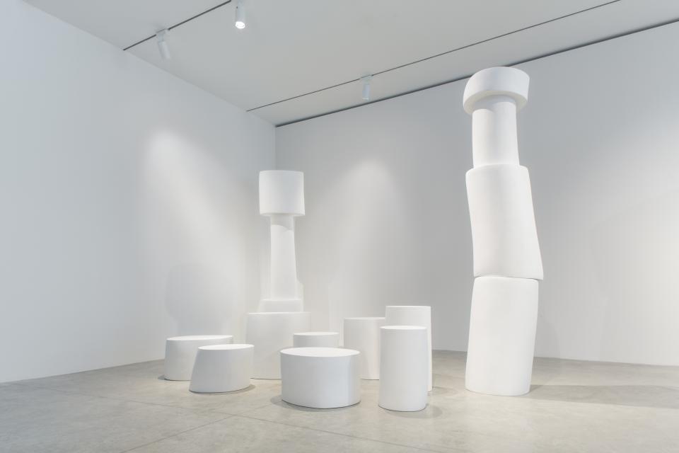 Sculptural white furniture pieces designed by Wendell Castle, showcasing organic forms in a minimalist gallery setting.
