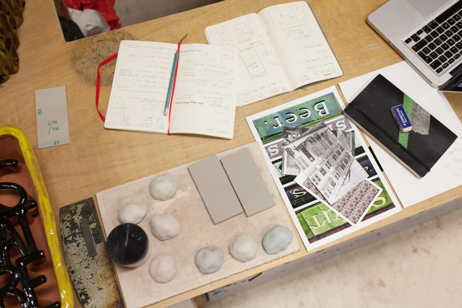 Workspace showing ceramic materials, sketches, and notes related to Matthew Raw's artistic process in post-industrial Manchester.