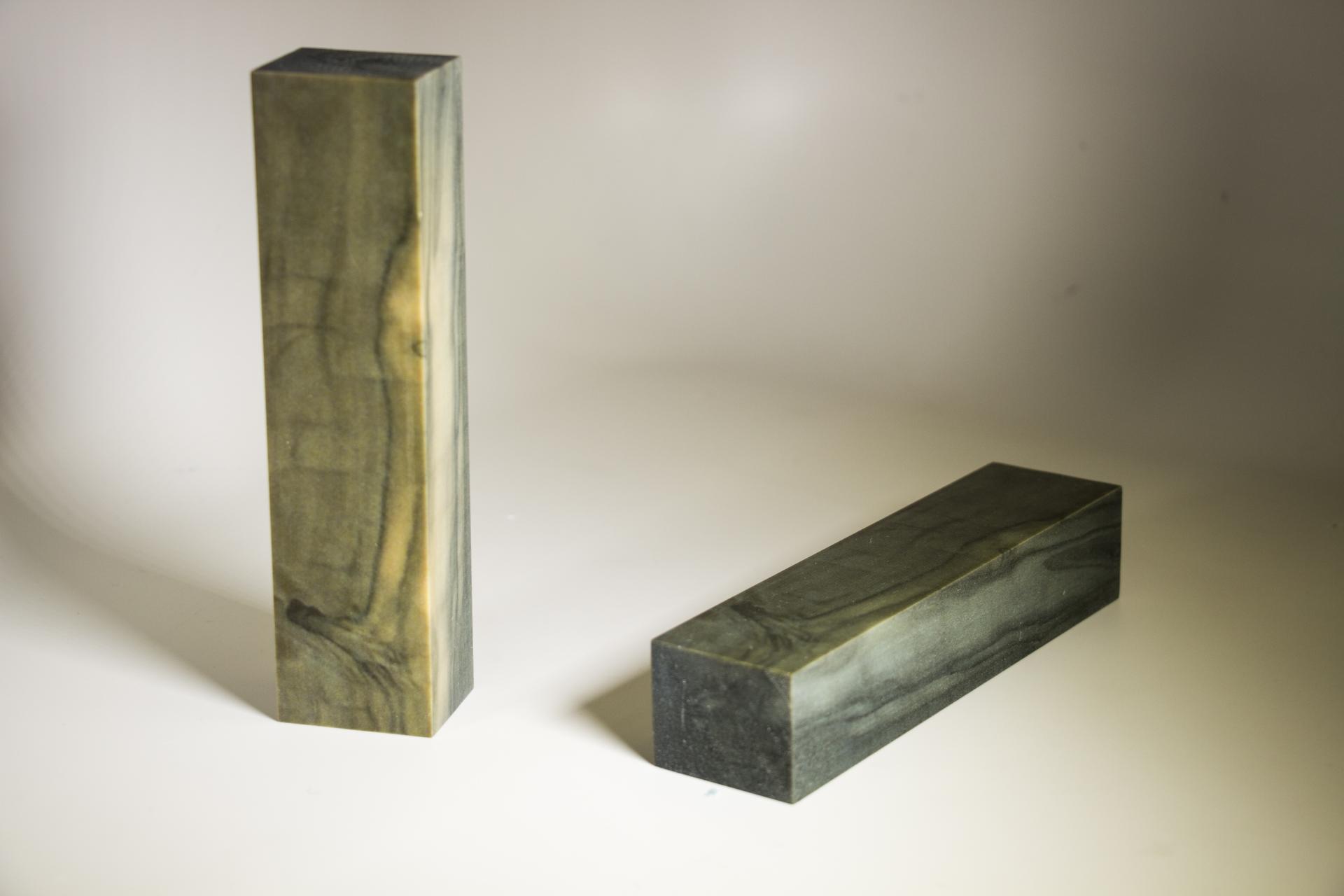 Sustainable alternative material resembling wood, showcased in two rectangular shapes with unique grain patterns.