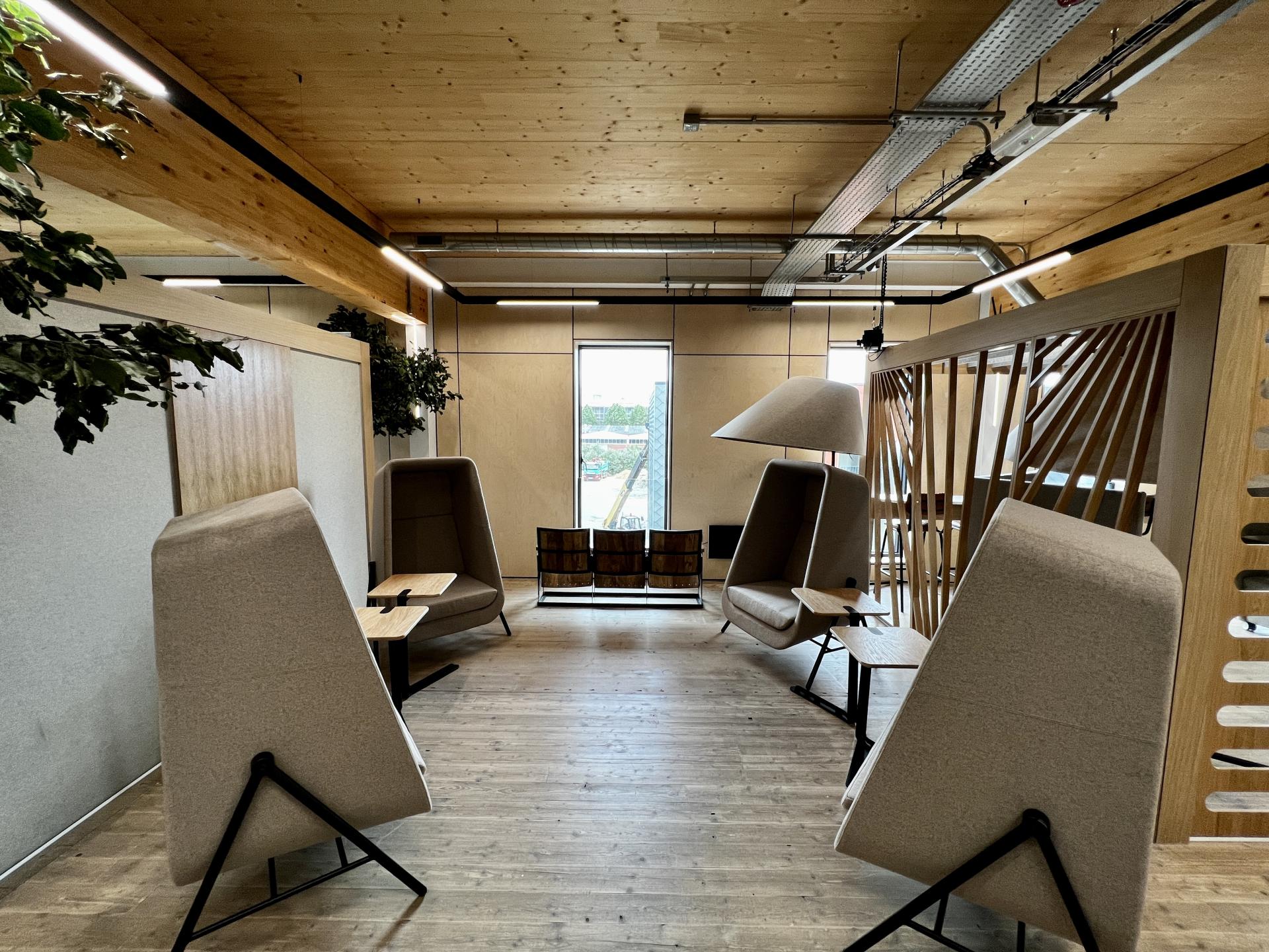 Sustainable and modern coworking space featuring cozy seating and natural decor, emphasizing Leeds’ commitment to net zero carbon design.