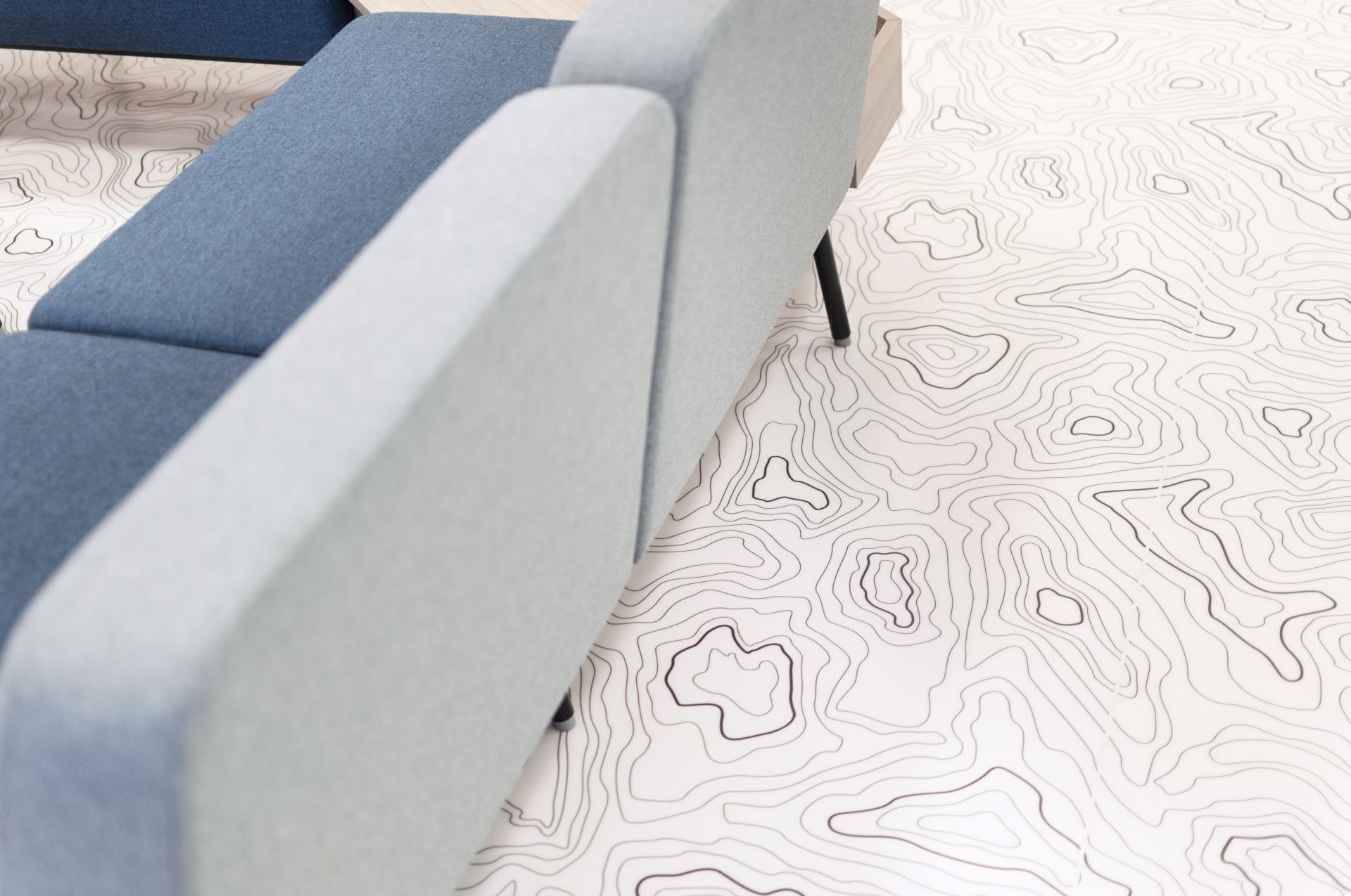 Stylish office seating with blue upholstery over a modern floor design resembling topographic maps.
