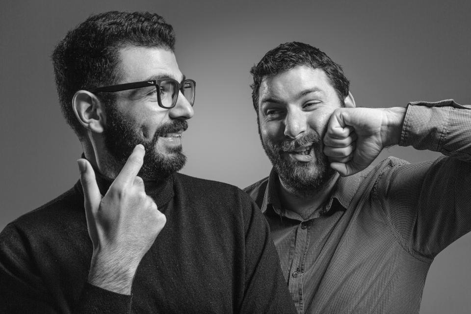 Two bearded men share a lighthearted moment, showcasing the creative spirit of Taner's Sons Design Studio.