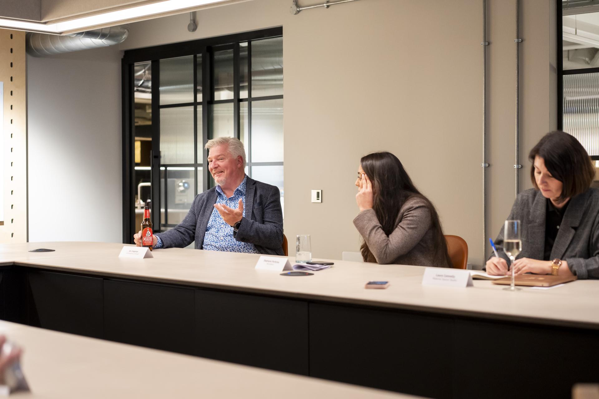 Discussion on workplace data impacts, featuring participants engaged in conversation at a modern conference table.