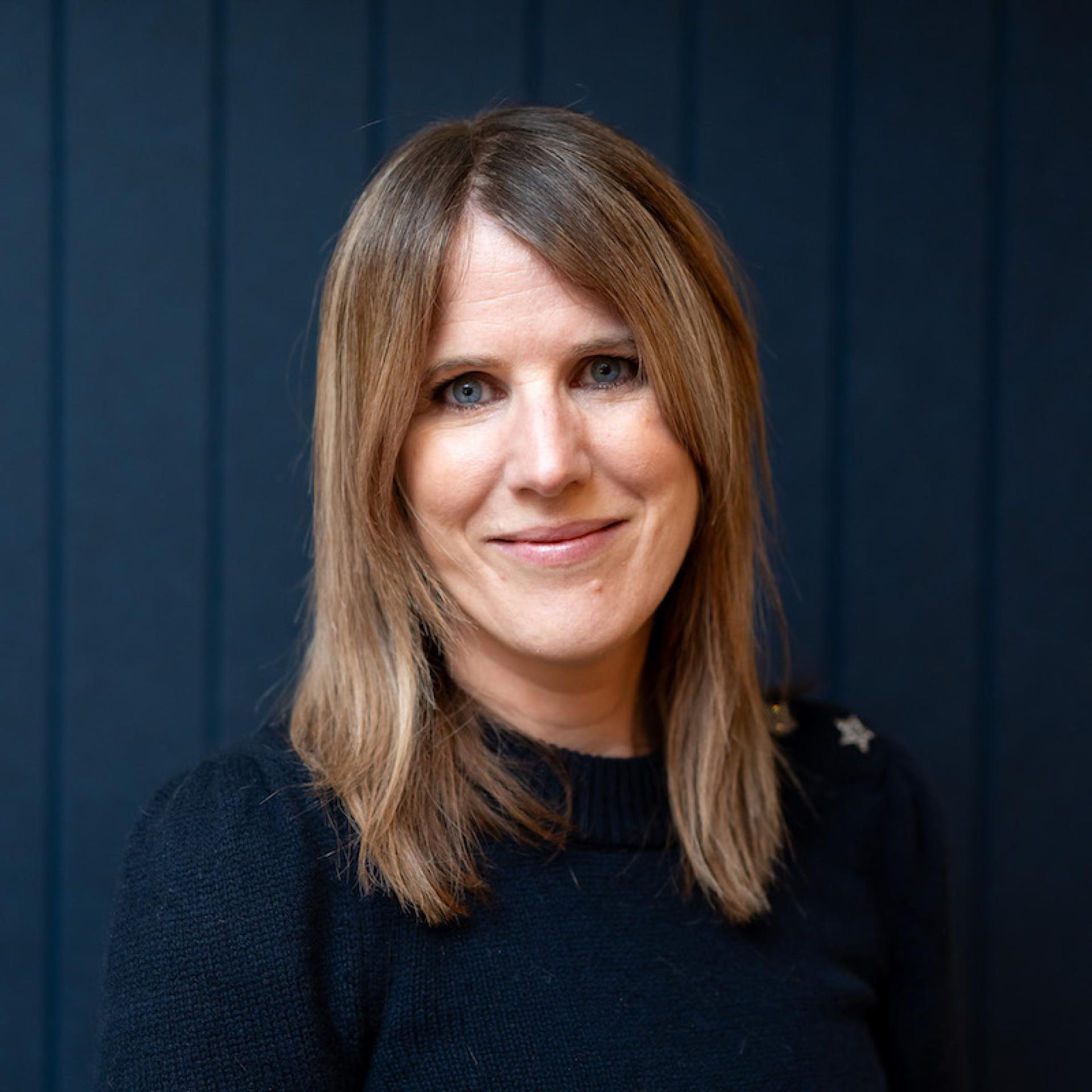 Portrait of a woman smiling, representing the evolving dynamics of modern workplace interactions and collaboration.