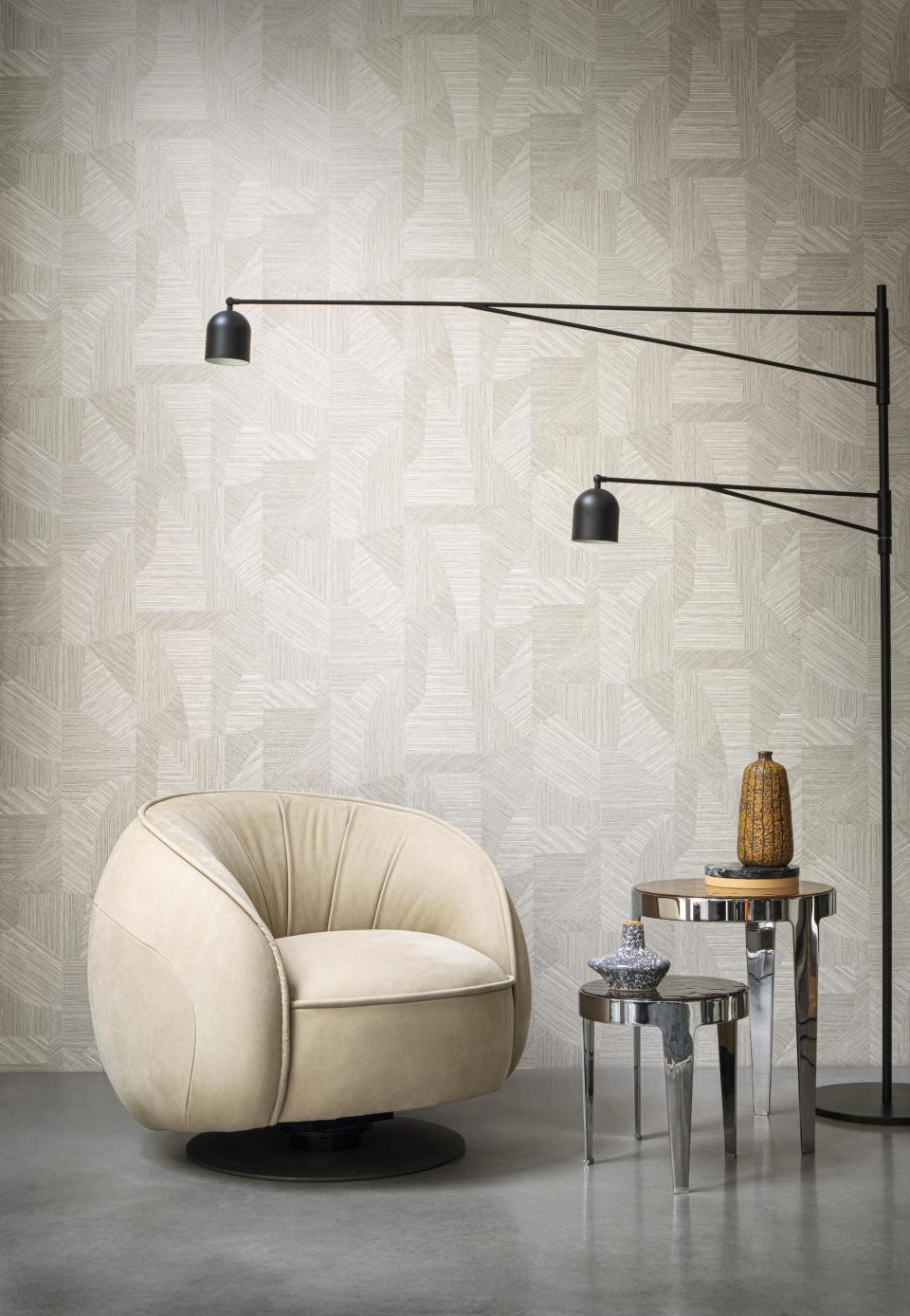 Elegant beige swivel chair alongside modern tables and a patterned wallpaper, inspired by the Tangram puzzle design.