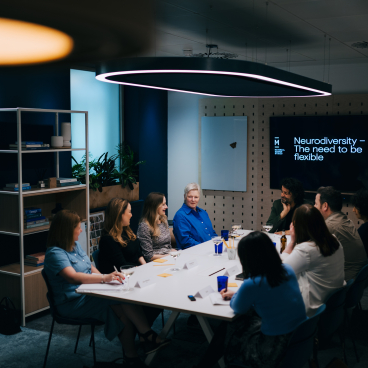 Roundtable discussion on neurodiversity at Material Source Studio, featuring diverse participants engaged in conversation about flexibility.