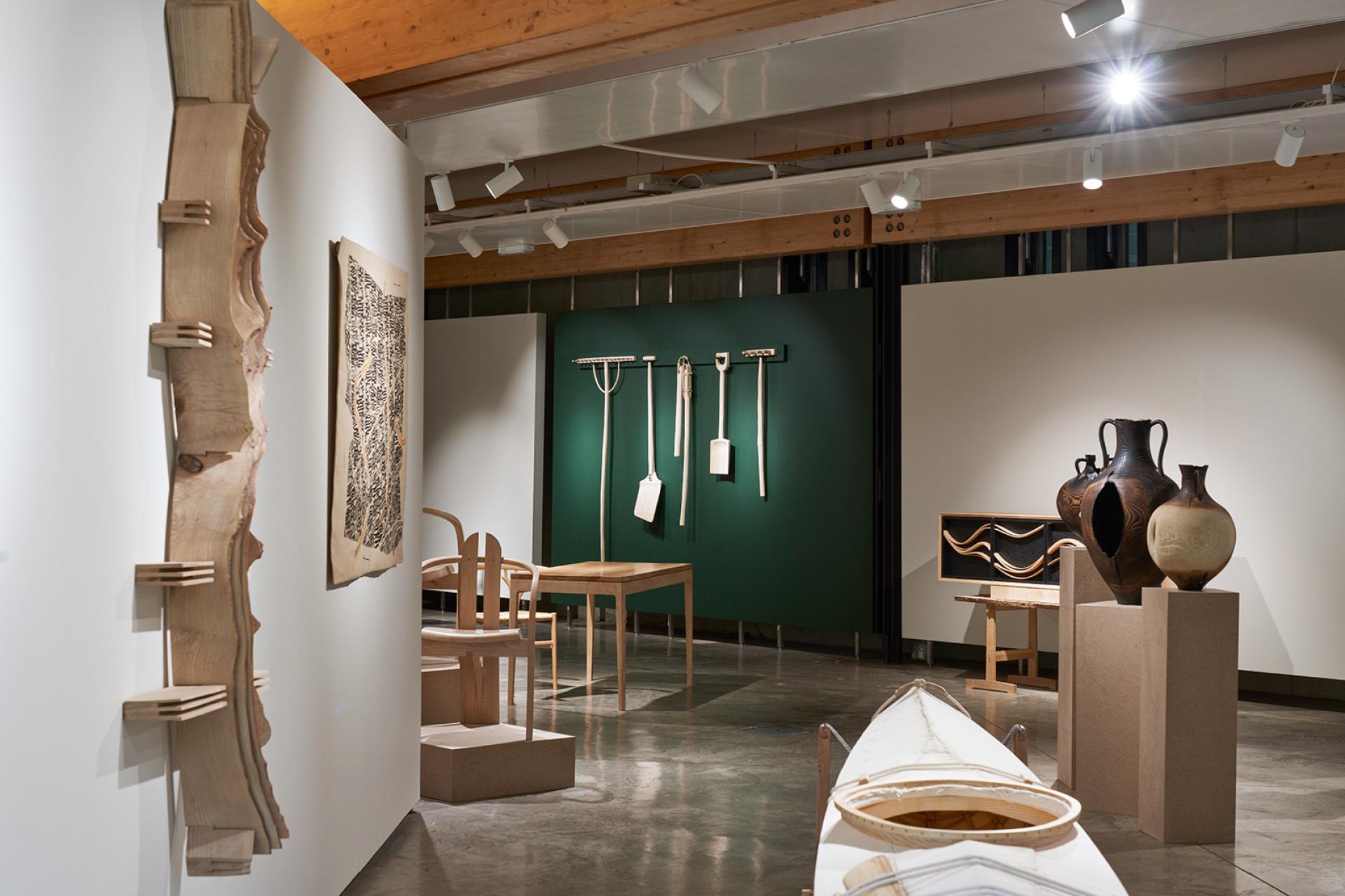 Exhibition showcasing ash wood craftsmanship with various sculptures, furniture, and pottery emphasizing Scotland's native ash tree.