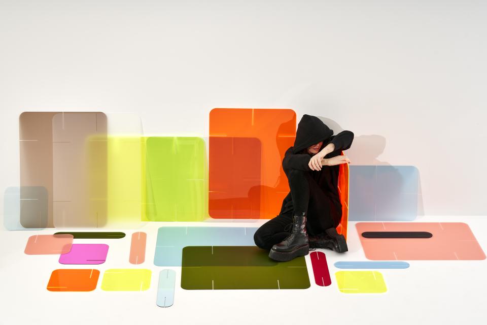 Colorful translucent panels surround a person sitting on the floor, showcasing Zahava Elenberg's innovative Clikclax design solution.