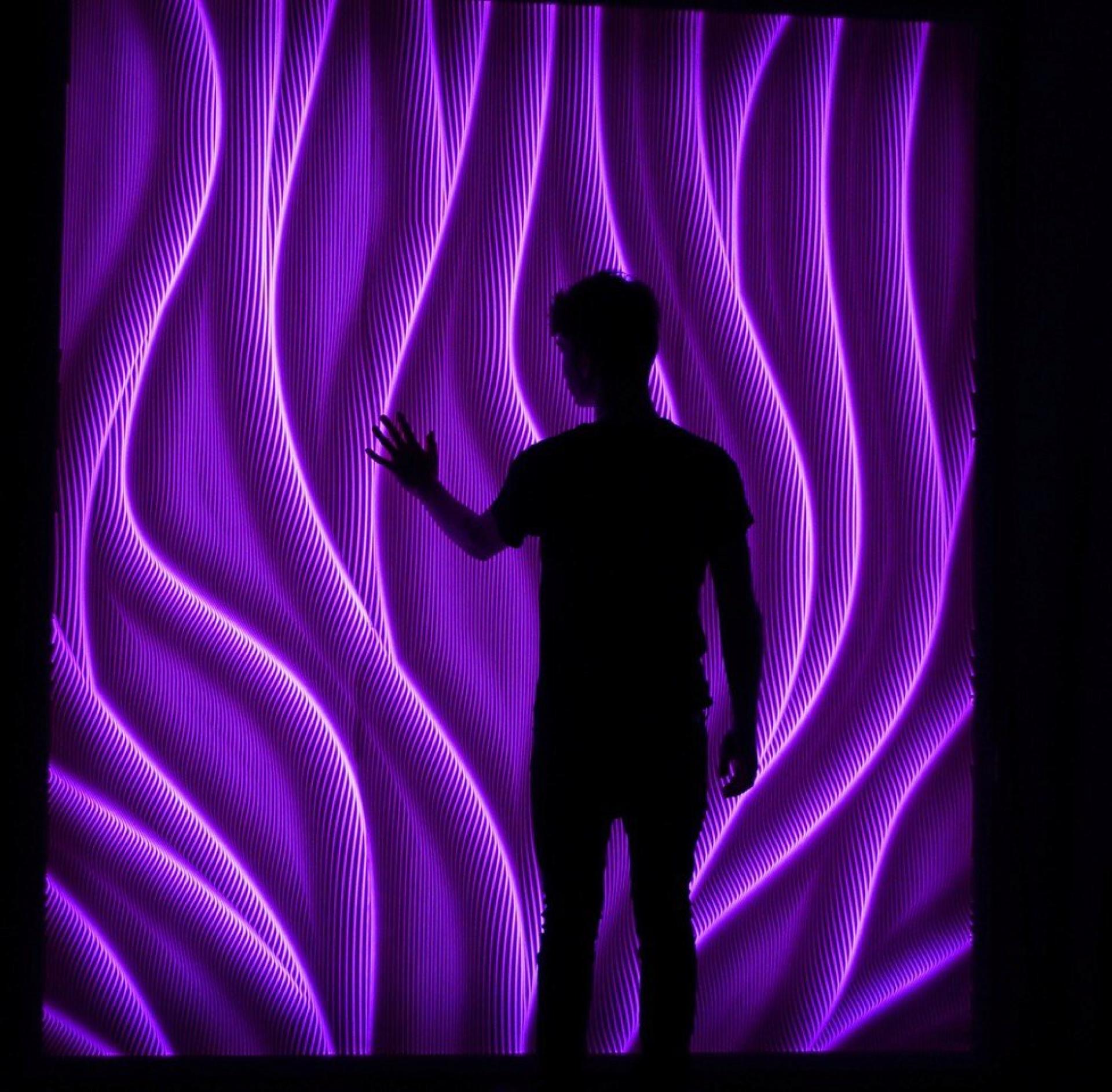 Multidimensional wall surface showcasing flowing purple light patterns, highlighting CDUK's innovative M|R Walls design.