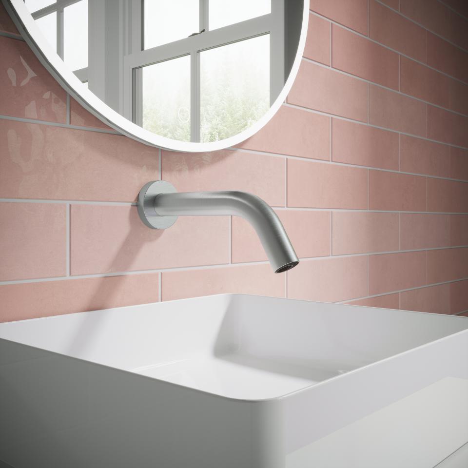 Modern sensor tap from Crosswater MPRO collection installed above a minimalist white sink and pink tiled wall.