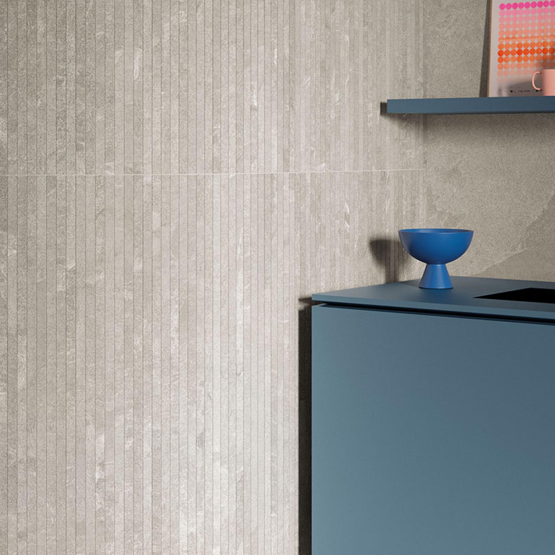 Contemporary interior featuring Grestec's Cellan collection with textured slate-like wall and modern blue cabinetry.