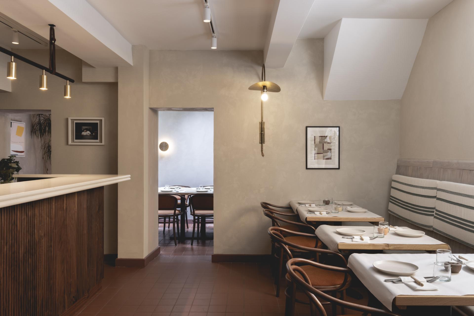 Sophisticated interior of Honey & Co Bloomsbury, showcasing minimalist design with wooden elements and elegant table settings.