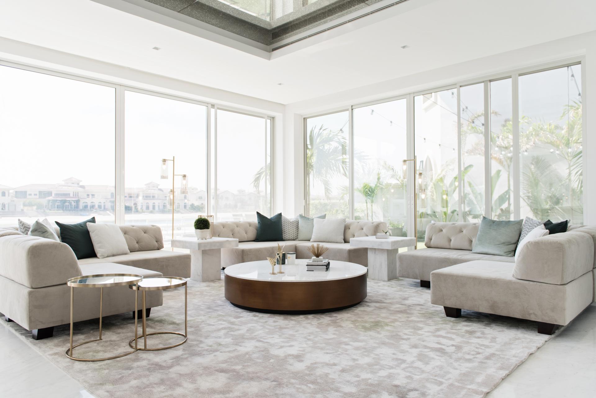 Minimalist living room by Sneha Divias Atelier, featuring plush seating and large windows overlooking The Palm Jumeirah.