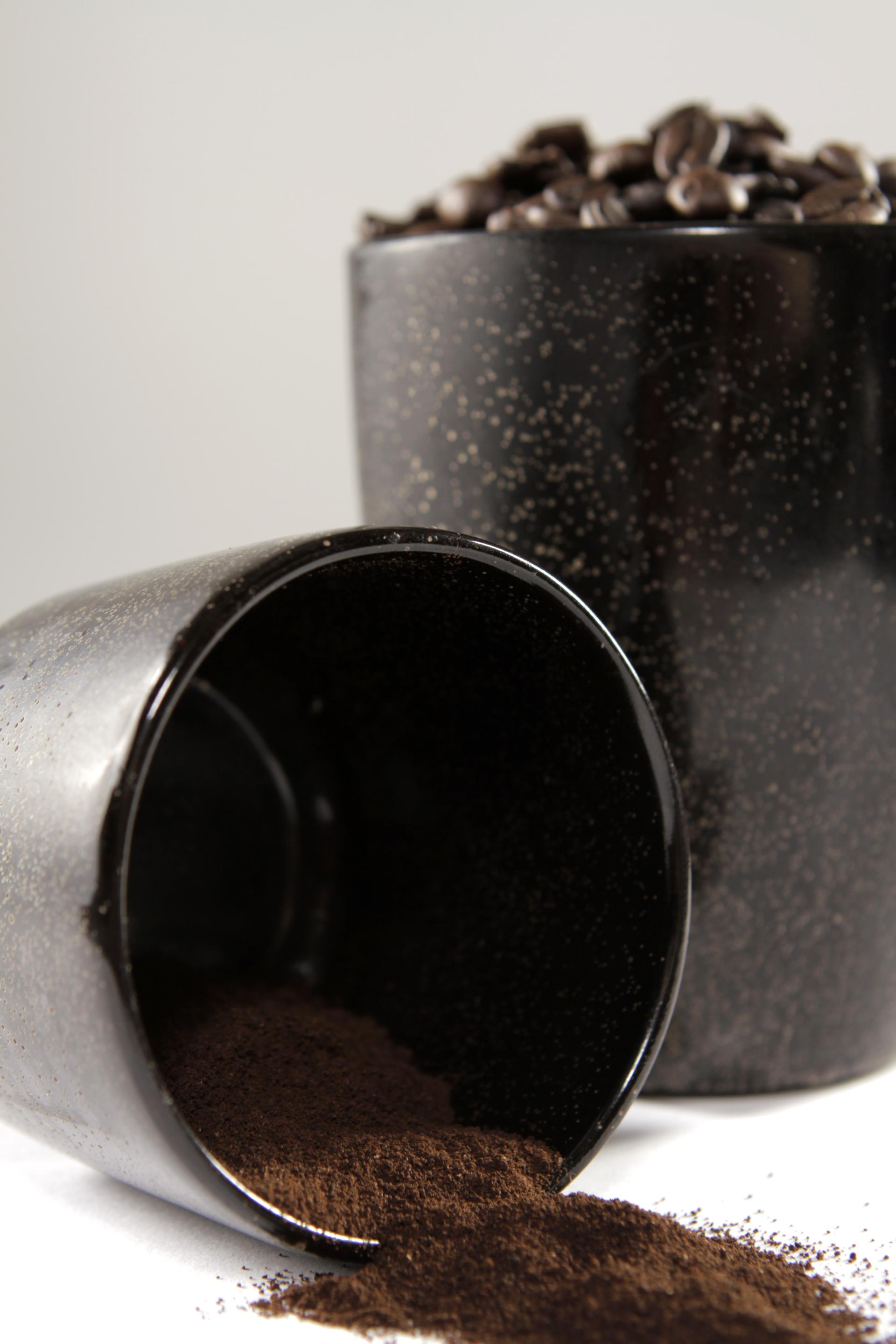 Lightweight black cups featuring coffee granules, highlighting That’s Caffeine's sustainable and biodegradable materials.