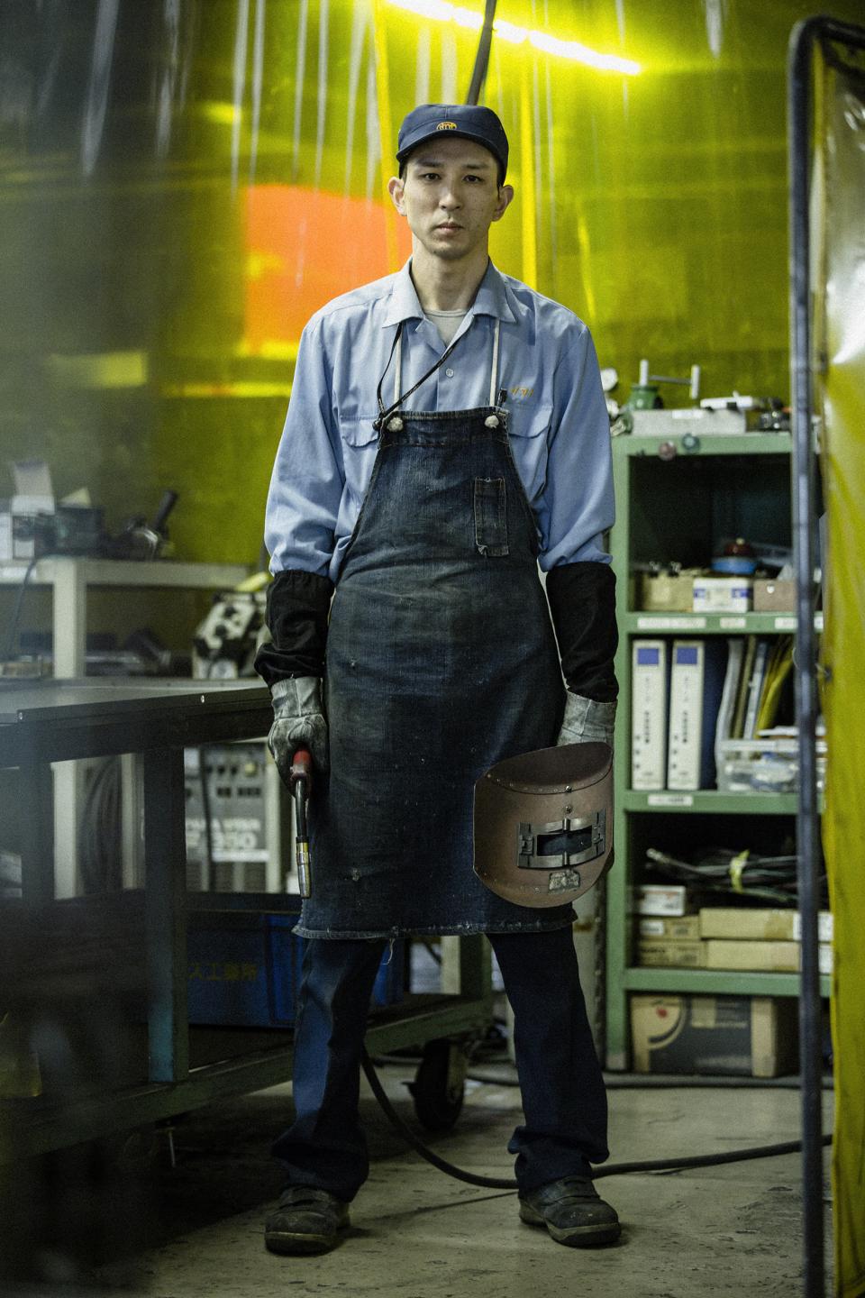 Craftsman holding welding equipment, showcasing traditional metal craftsmanship in Tsubame-Sanjo at Japan House London exhibition.