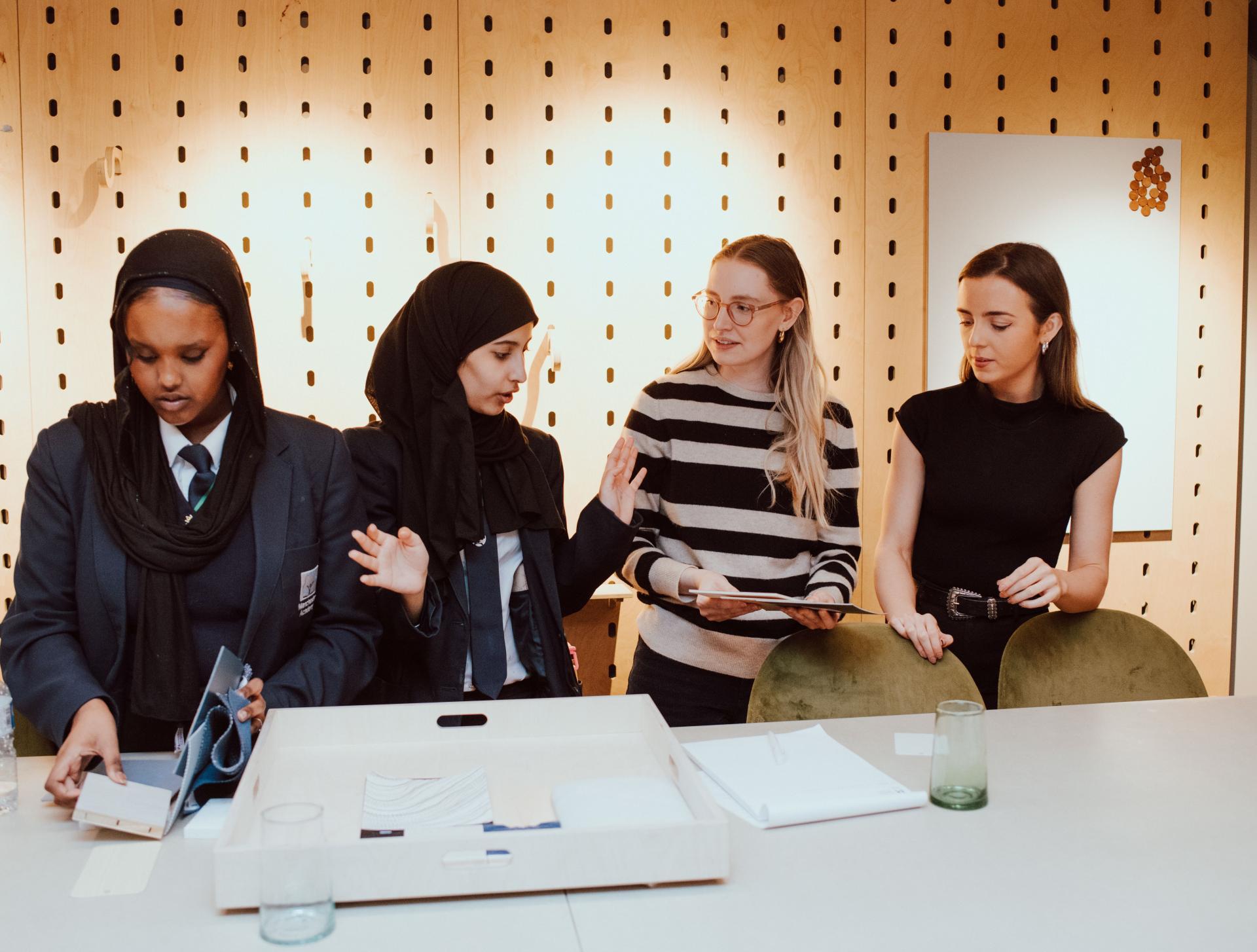Students and mentors collaborating on interior design projects at SCENE Interiors, expressing ideas and creativity in a learning environment.