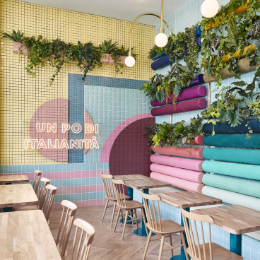 Colorful interior design of Piada restaurant in Lyon, featuring unique wall art, greenery, and wooden furniture elements.