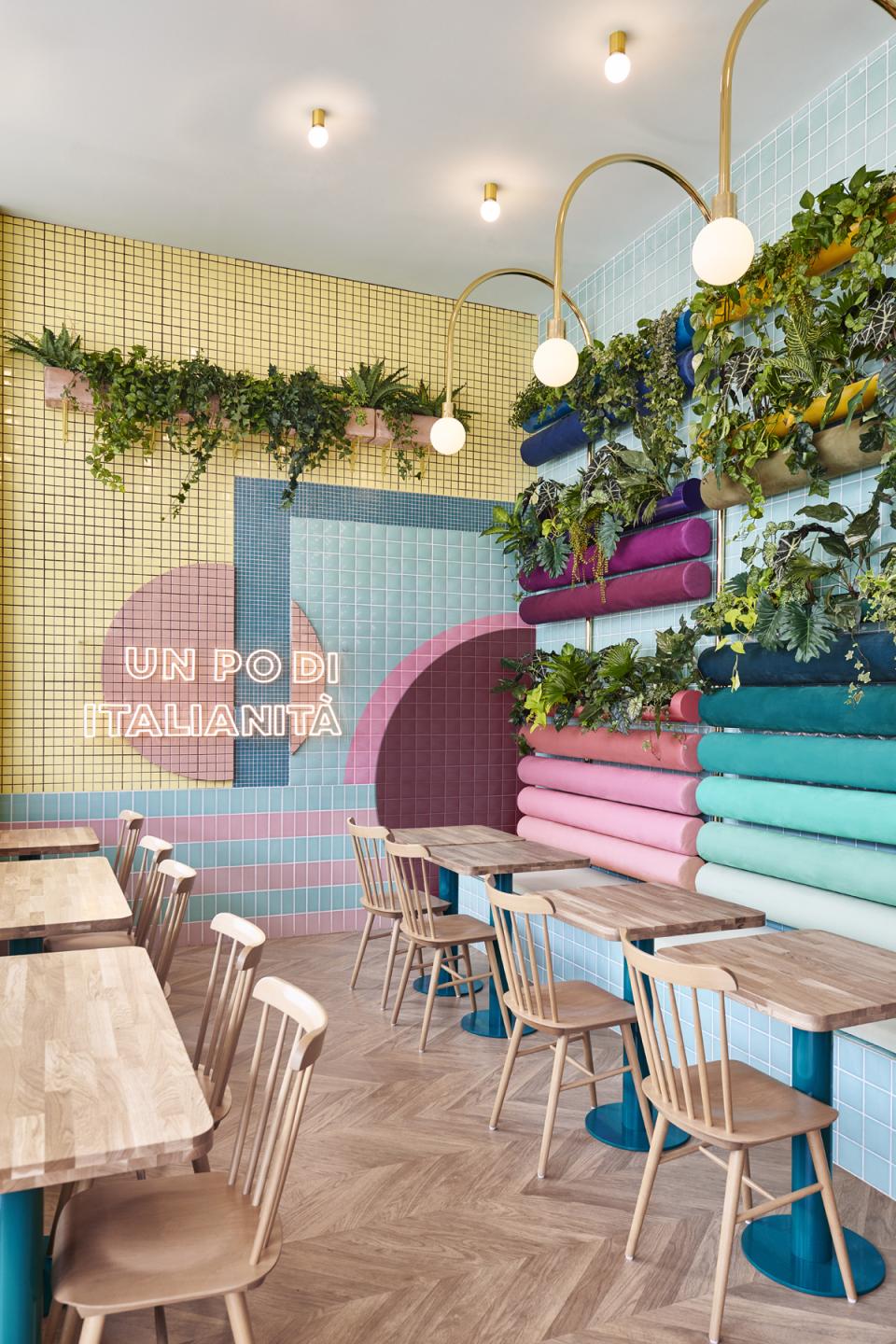 Colorful interior design of Piada restaurant in Lyon, featuring unique wall art, greenery, and wooden furniture elements.