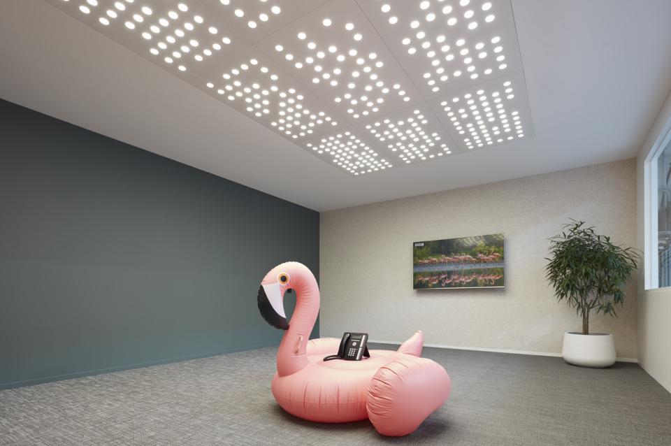 Brightly lit workspace featuring an inflatable pink flamingo, enhancing Studio Y's innovative design for Ambience.