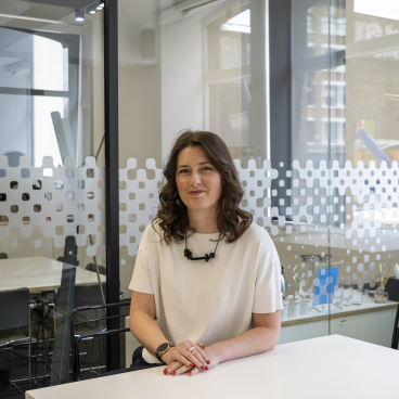 Leanne Wookey seated at a modern table in a light-filled office, reflecting a sustainability-focused creative environment in the North West.