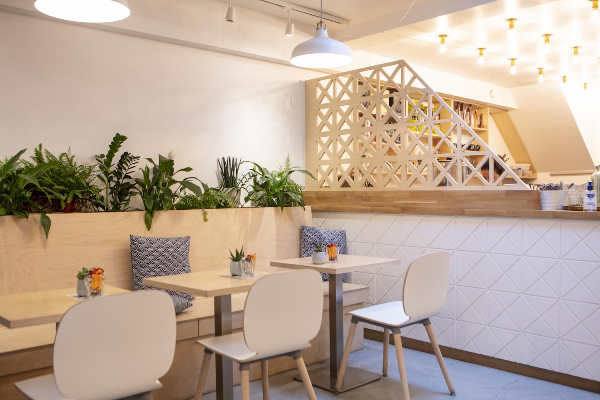 Modern café interior designed by Liqui Group, featuring light wood, greenery, and stylish seating, located in Dublin.