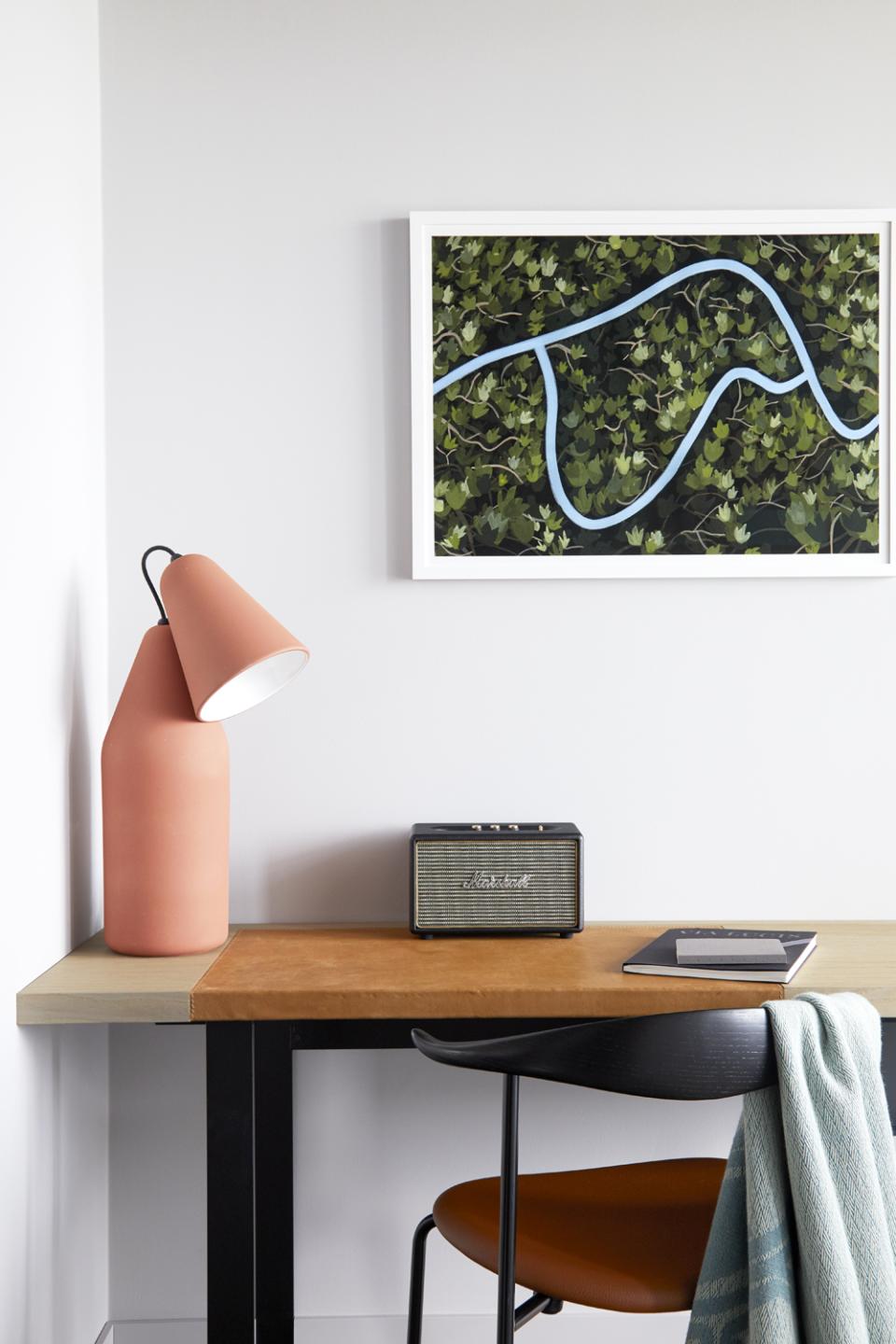 Stylish workspace featuring a modern lamp, vintage speaker, artwork, and a cozy chair at PURO Kraków Kazimierz.