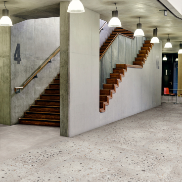 Stylish commercial space featuring wooden stairs and safety flooring, highlighting Amtico's focus on design and functionality.