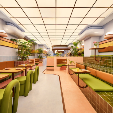 Vibrant interior of a Barcelona ice cream parlour featuring a reimagined Art Deco design with colorful seating and plants.