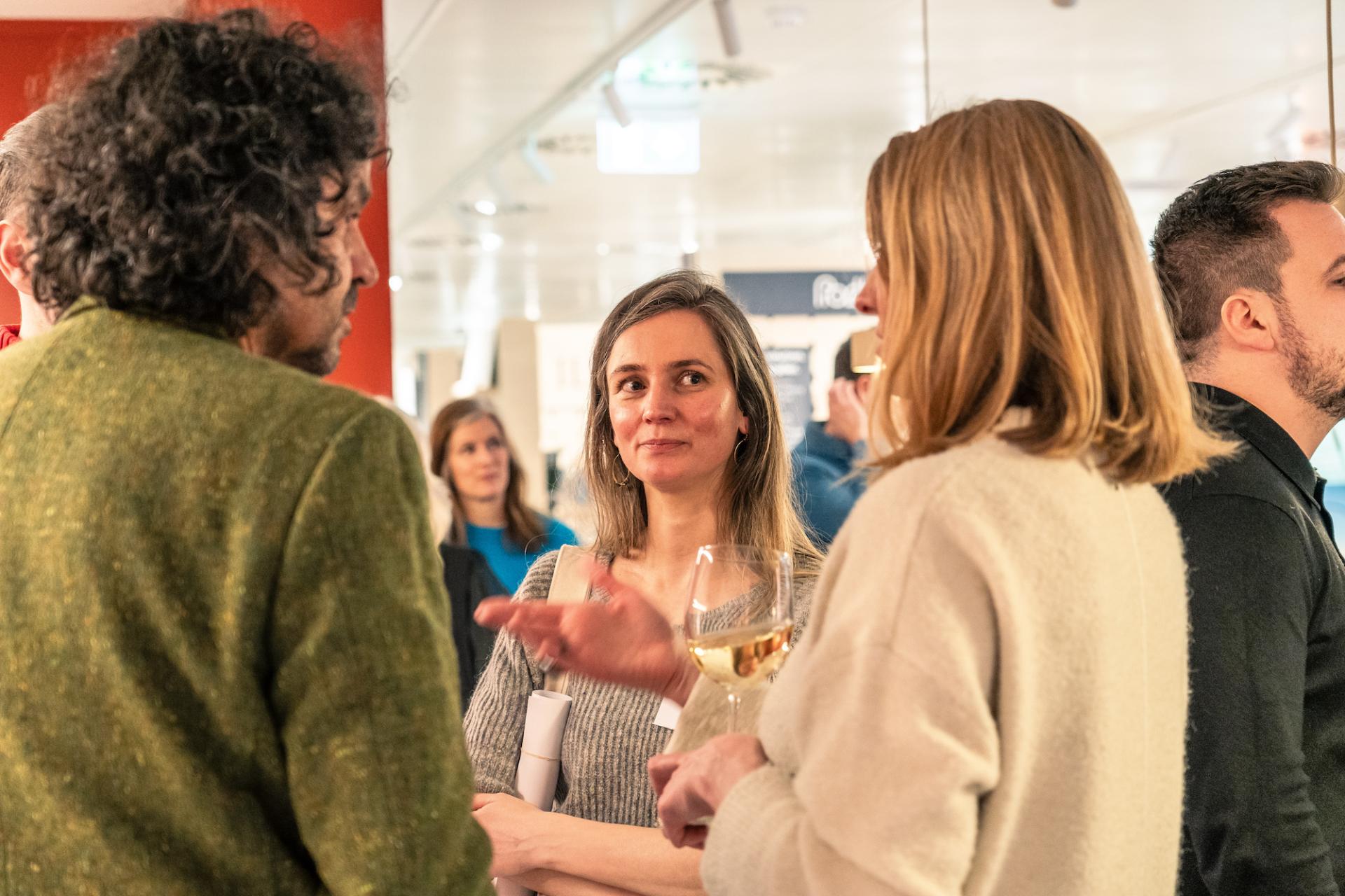 Attendees engage in conversation at Material Source Studio in Glasgow, discussing sustainability and its implications.